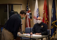 JOINT BASE LANGLEY-EUSTIS, Va. (Jan. 25, 2021) David Feser, a policy and doctrine analyst at Joint Task Force Civil Support (JTF-CS), administers a temperature check to Brooks Holder, the JTF-CS financial management director, at the command’s headquarters as a part of COVID-19 force health protection measures during exercise Sudden Response 21.