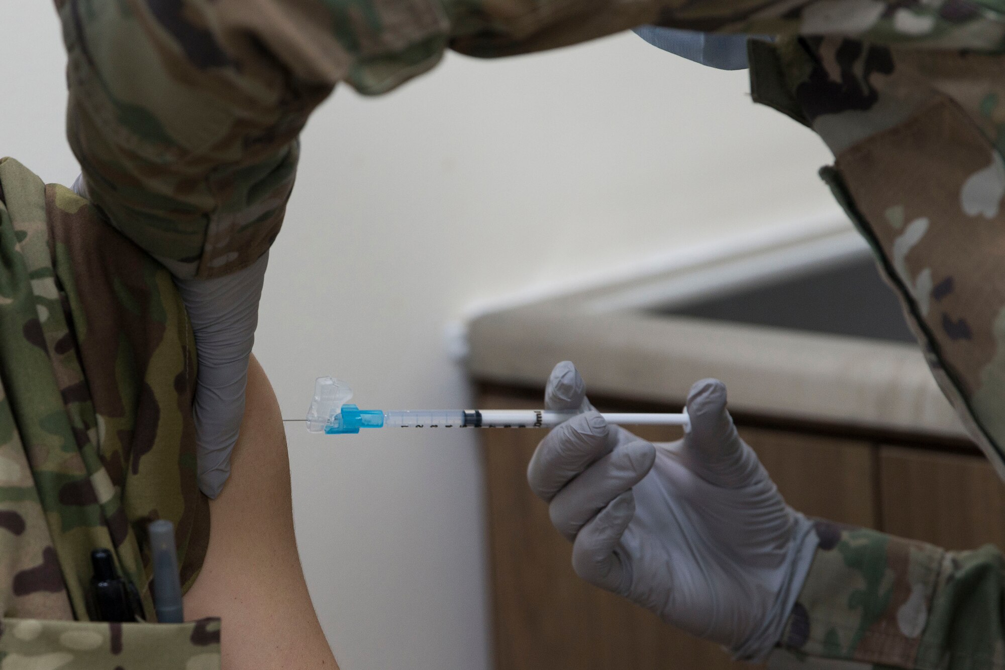 A medical technician assigned to the 380th Expeditionary Medical Group (EMDG) administers a voluntary COVID-19 vaccine to a 380th EMDG clinic staff member at Al Dhafra Air Base, United Arab Emirates, Jan. 24, 2021.