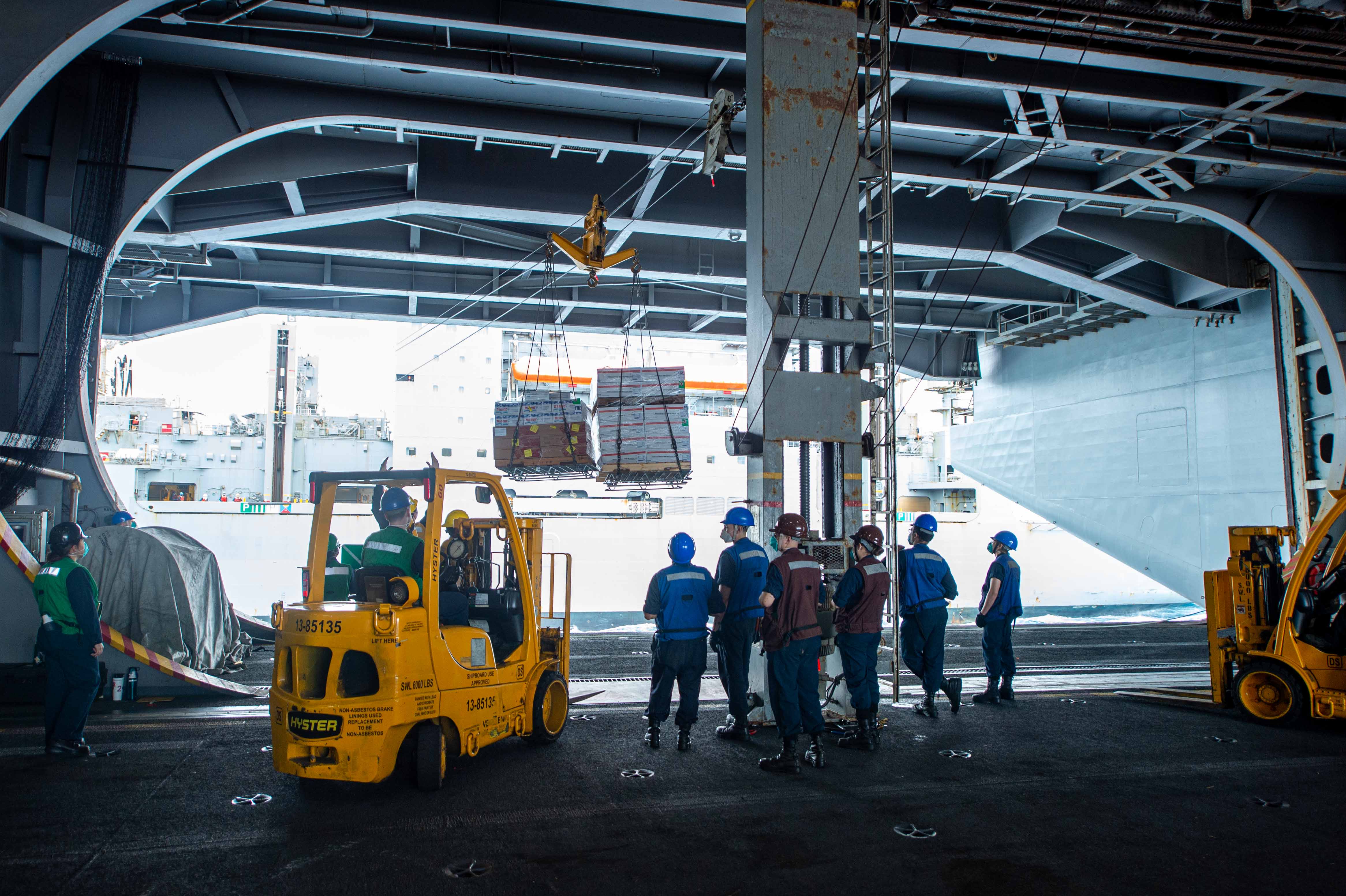 Sailors receive supplies during a replenishment-at-sea from the dry cargo ship USNS Medgar Evers (T-AKE 13) aboard the Nimitz-class aircraft carrier USS Dwight D. Eisenhower (CVN 69).