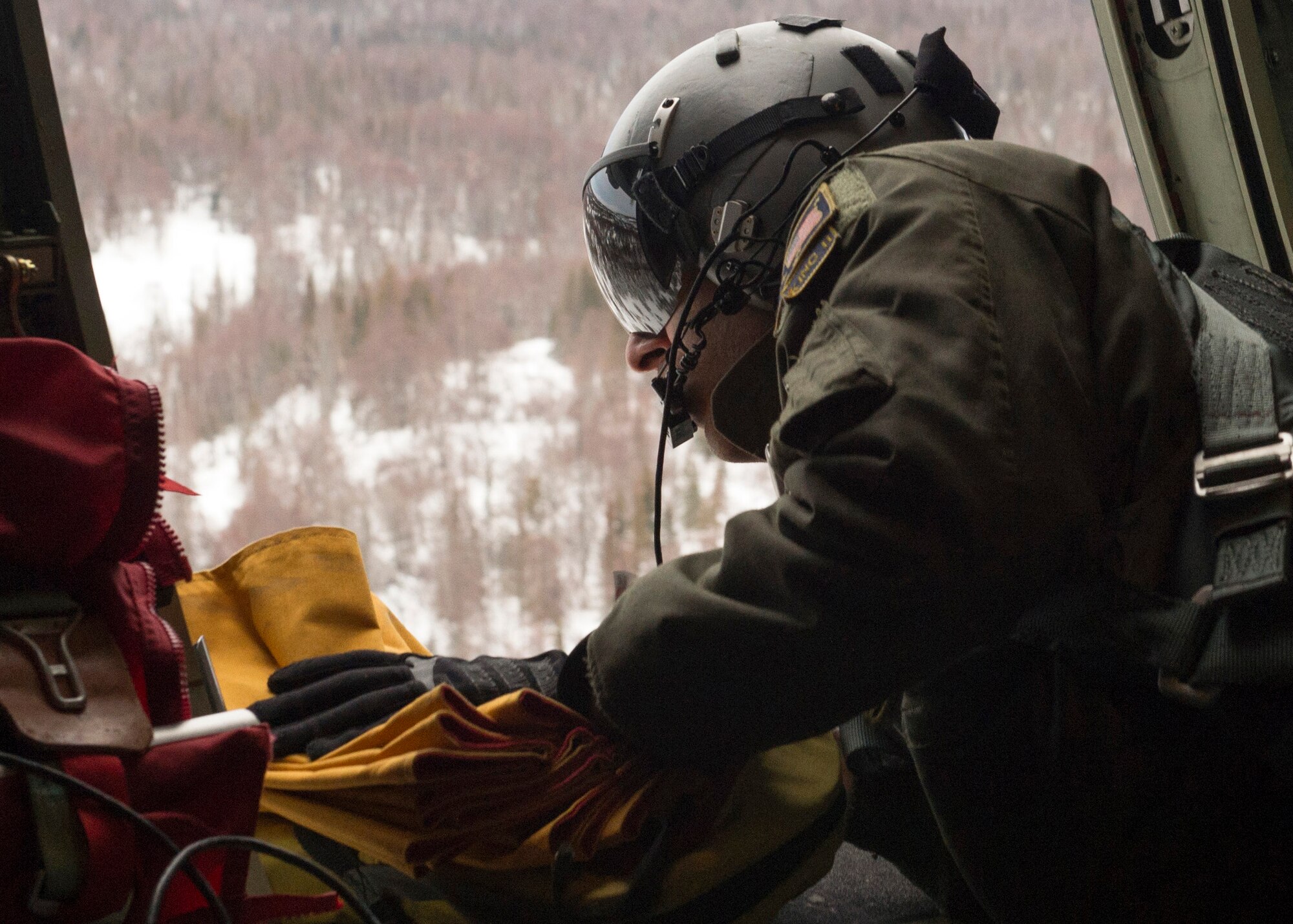 U.S. Air Force Senior Airman Marcus Moloney, a loadmaster assigned to the 211th Rescue Squadron, Alaska Air National Guard, drops a freefall bundle of supplies to a simulated victim during a search and rescue exercise over Alaska, Jan. 21, 2021, as part of Operation Noble Defender. Operation Noble Defender is a North American Air Defense Command air-defense operation which allows dynamic training for operational readiness in an arctic environment.