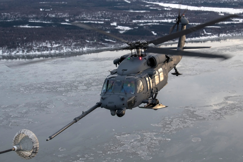 A U.S Air Force HH-60G Pave Hawk helicopter assigned to the 210th Rescue Squadron, Alaska Air National Guard, conducts aerial refueling from a U.S. Air Force HC-130J Combat King II assigned to the 211th Rescue Squadron, Alaska Air National Guard, over Alaska, Jan. 21, 2021, during Operation Noble Defender. Operation Noble Defender is a North American Air Defense Command air-defense operation which allows dynamic training for operational readiness in an arctic environment.