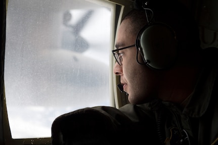 U.S. Air Force Senior Airman Marcus Moloney, a loadmaster assigned to the 211th Rescue Squadron, Alaska Air National Guard, looks for a simulated search-and-rescue target over Alaska, Jan. 21, 2021, during Operation Noble Defender. Operation Noble Defender is a North American Air Defense Command air-defense operation which allows dynamic training for operational readiness in an arctic environment.