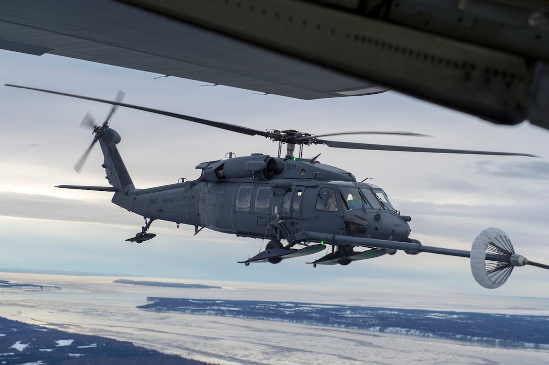 A U.S Air Force HH-60G Pave Hawk helicopter assigned to the 210th Rescue Squadron, Alaska Air National Guard, conducts aerial refueling from a U.S. Air Force HC-130J Combat King II assigned to the 211th Rescue Squadron, Alaska Air National Guard, over Alaska, Jan. 21, 2021, during Operation Noble Defender. Operation Noble Defender is a North American Air Defense Command air-defense operation which allows dynamic training for operational readiness in an arctic environment.