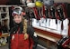 A woman wearing ski gear is surrounded by ski gear