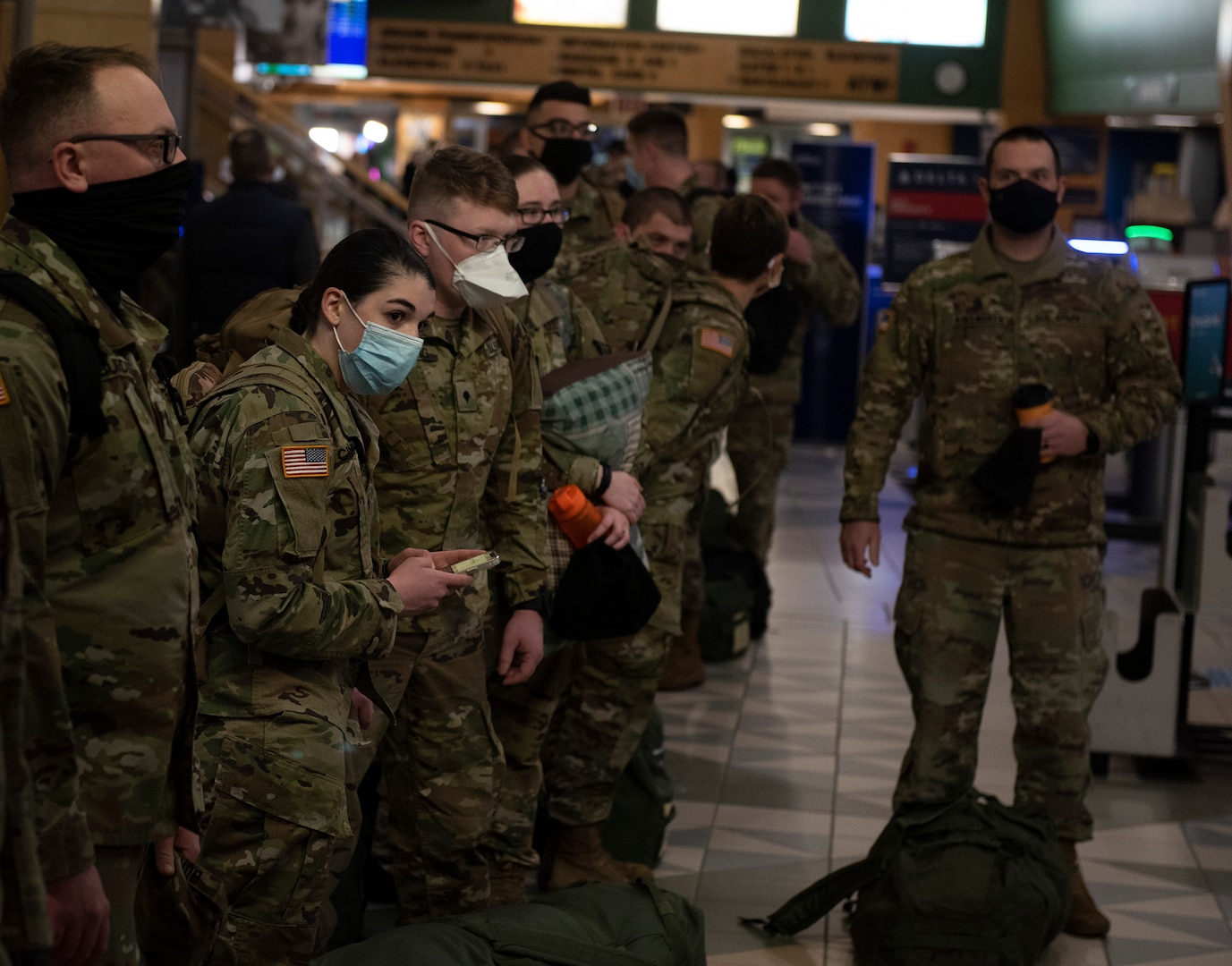 Soldiers with the Vermont National Guard's 172nd Law Enforcement Detachment wait to check their bags at Burlington International Airport in South Burlington, Vermont, Jan. 26, 2021. The Soldiers will deploy to the U.S. European Command area of responsibility to support Operation Freedom's Sentinel. (U.S. Army National Guard photo by Don Branum)