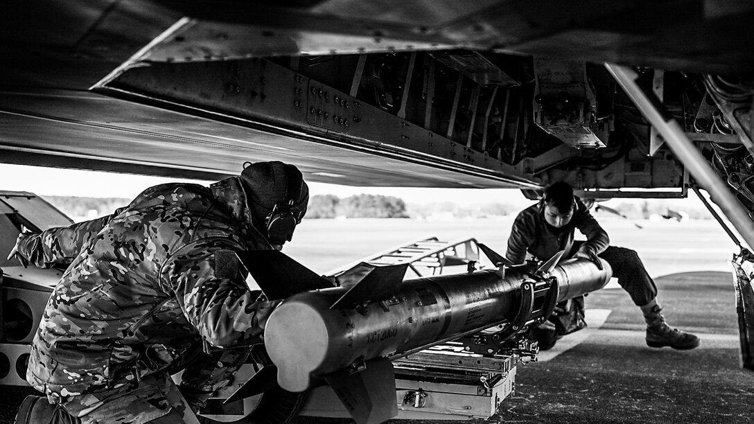 Airmen load a missile onto an aircraft.