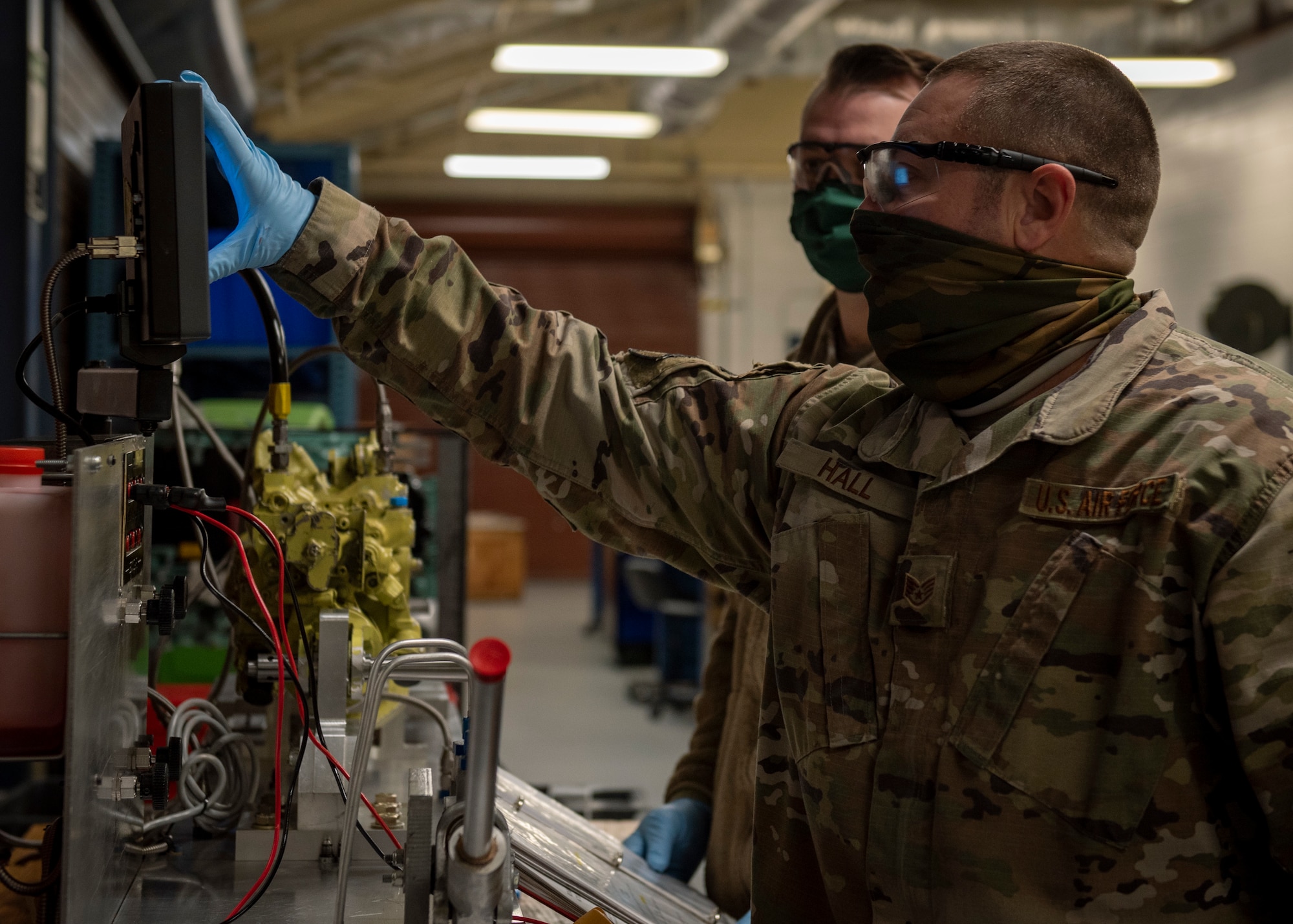 Staff Sgt. Steven Hall, 4th Component Maintenance Squadron centralized repair facility expeditor (front), and Tech. Sgt. Jeremy Fannin, 4 CMS centralized repair facility NCO in charge (back), prepare to test a stabilator actuator at Seymour Johnson Air Force Base, North Carolina, Jan. 7, 2021.