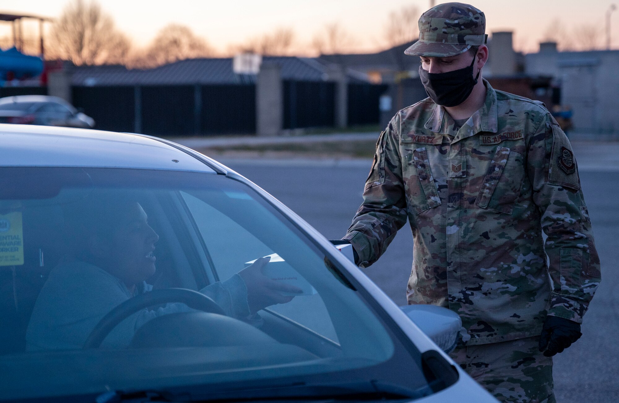 Tech. Sgt. Matthew Kurtz, 436th Operations Support Squadron air traffic control tower watch supervisor, gives out a meal at a deployed spouses drive-thru dinner event Jan. 21, 2021, at Dover Air Force Base, Delaware. The event provided meals, gift bags and toys to families of deployed service members in recognition of their sacrifice. The deployed spouses dinner is one of many ways Team Dover takes care of service members and their loved ones. (U.S. Air Force photo by Airman 1st Class Cydney Lee)