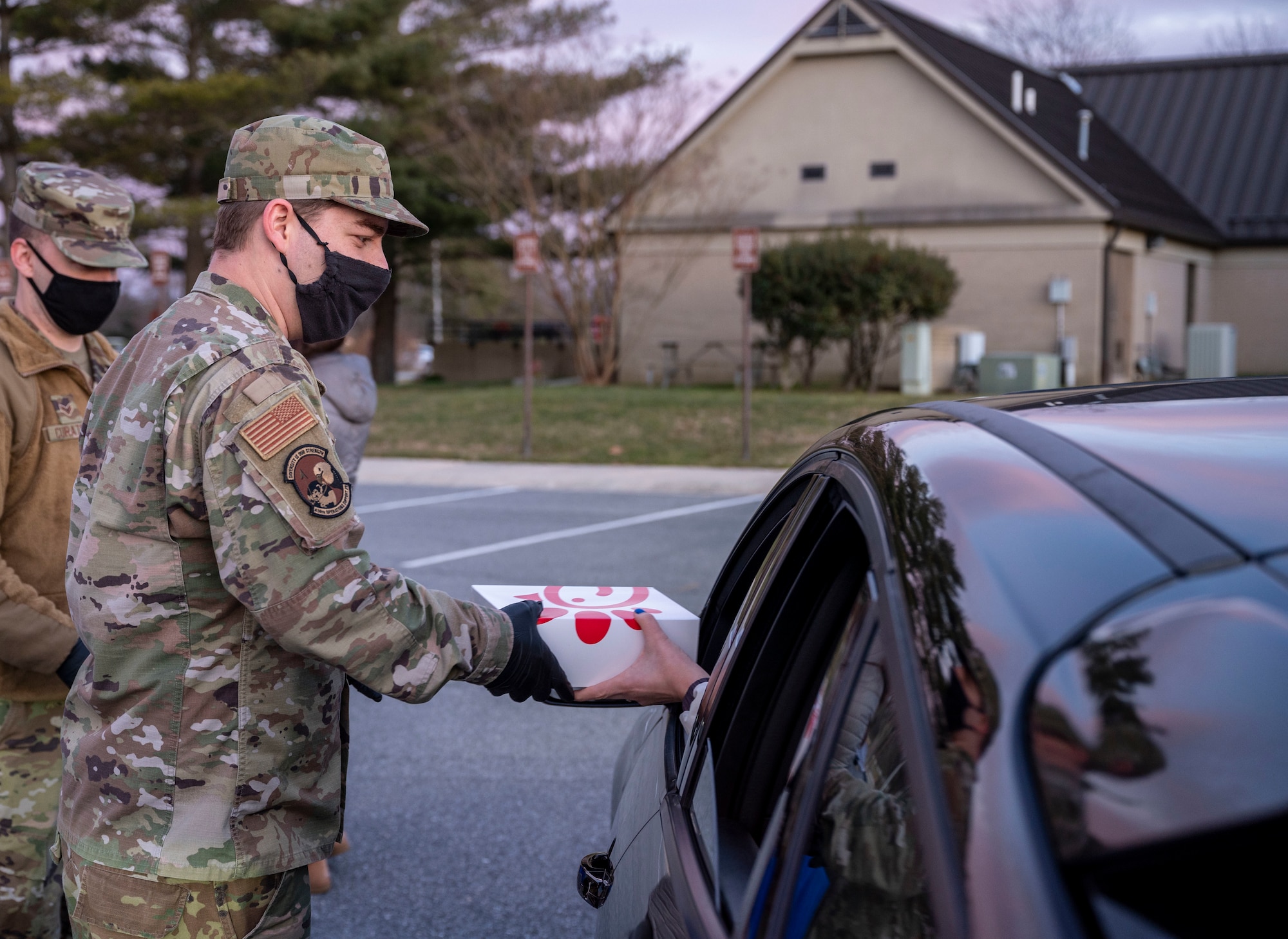 Tech. Sgt. Matthew Kurtz, 436th Operations Support Squadron air traffic control tower watch supervisor, hands out sandwiches at a deployed spouses drive-thru dinner Jan. 21, 2021, at Dover Air Force Base, Delaware. The event provided meals, gift bags and toys to families of deployed service members in recognition of their sacrifice. The deployed spouses dinner is one of many ways Team Dover takes care of service members and their loved ones. (U.S. Air Force photo by Airman 1st Class Cydney Lee)