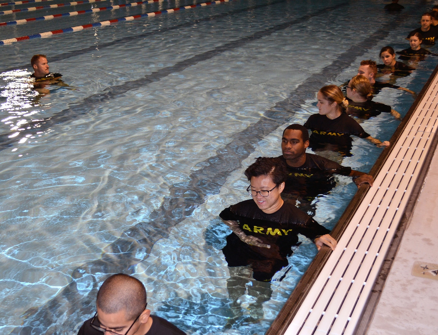Army Staff Sgt. Timothy S. McCoole (left), a Drill Sergeant with the Gladiator program at Joint Base San Antonio-Fort Sam Houston, leads a group of Soldier medics in training through morning exercises at the JBSA-Fort Sam Houston aquatic center.