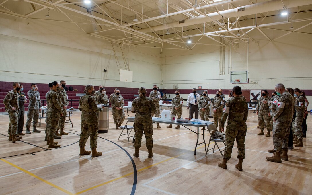 Airmen from the 4th Medical Group gather in the gym to discuss the process of administering the COVID-19 vaccination at Seymour Johnson Air Force Base, North Carolina, Jan. 15, 2021.