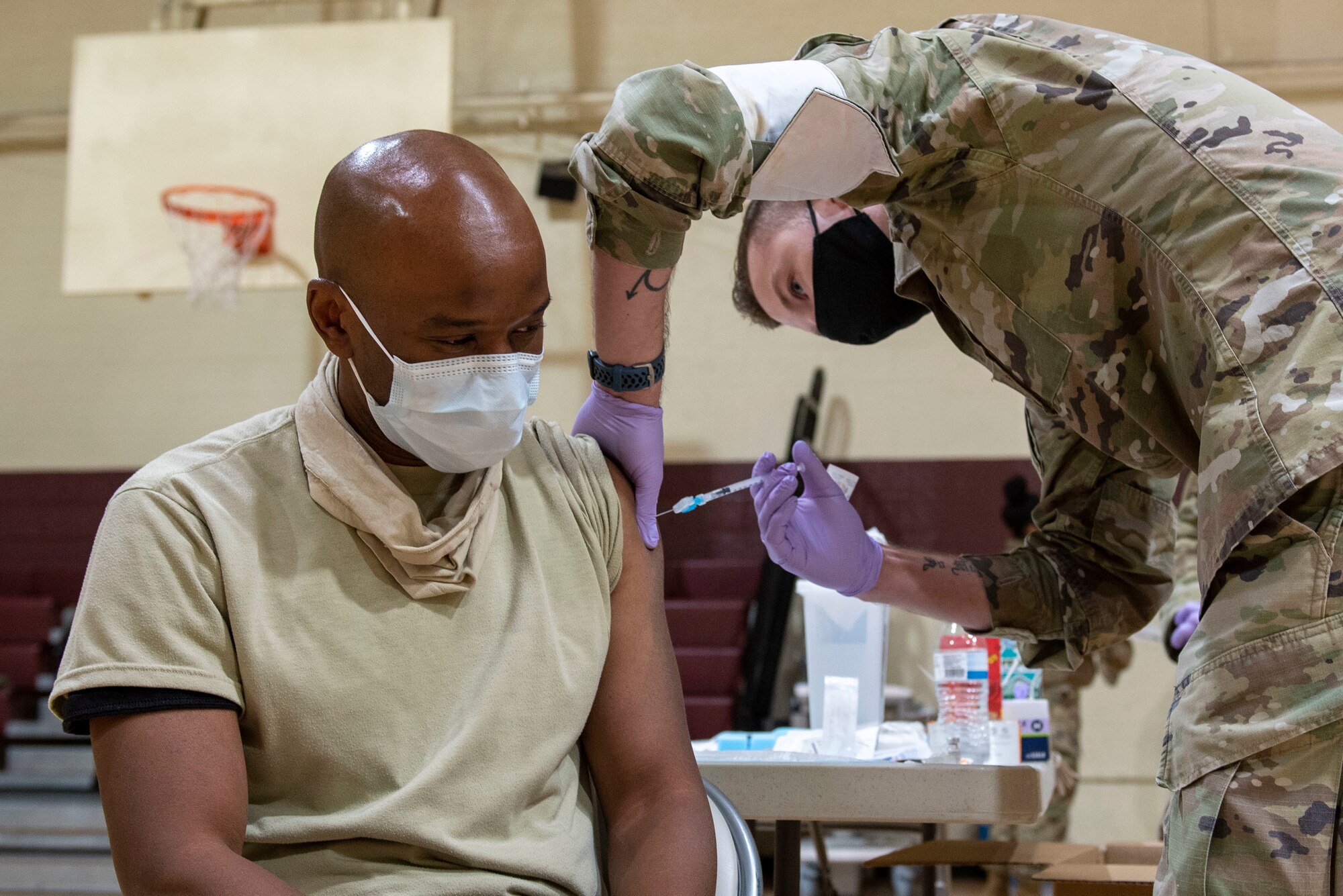 Senior Airman  IraHopkins, 4th Healthcare Operation Squadron medical technician (right), injects Lt. Col. Jonathan Davis, 4th Operational Medical Readiness Squadron primary care physician (left), with the COVID-19  vaccine at Seymour Johnson Air Force Base, North Carolina, Jan. 15, 2021.