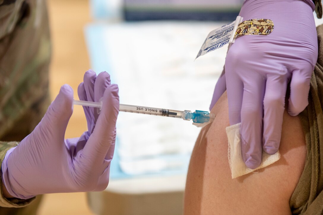 Staff Sgt. Candice Stafford, 4th Healthcare Operation Squadron medical technician, administers a COVID-19 vaccine to an Airman at Seymour Johnson Air Force Base, North Carolina, Jan. 15, 2021.