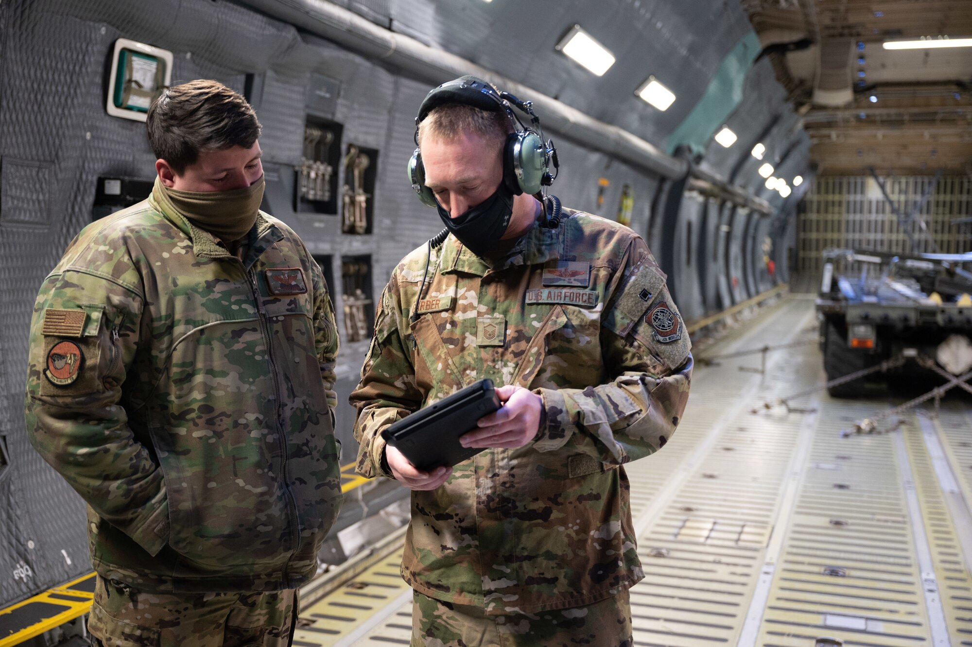 Master Sgt. Daniel Garber, 9th Airlift Squadron loadmaster, reviews a preflight checklist with Staff Sgt. Jesse Garza, 9th AS loadmaster, on a C-5M Super Galaxy at Dover Air Force Base, Delaware, Jan. 19, 2021. The 9th AS, also known as the “Proud Pelicans,” routinely flies local training missions to maintain operational readiness in support of the nation’s outsized global airlift capability. (U.S. Air Force photo by Airman 1st Class Faith Schaefer)