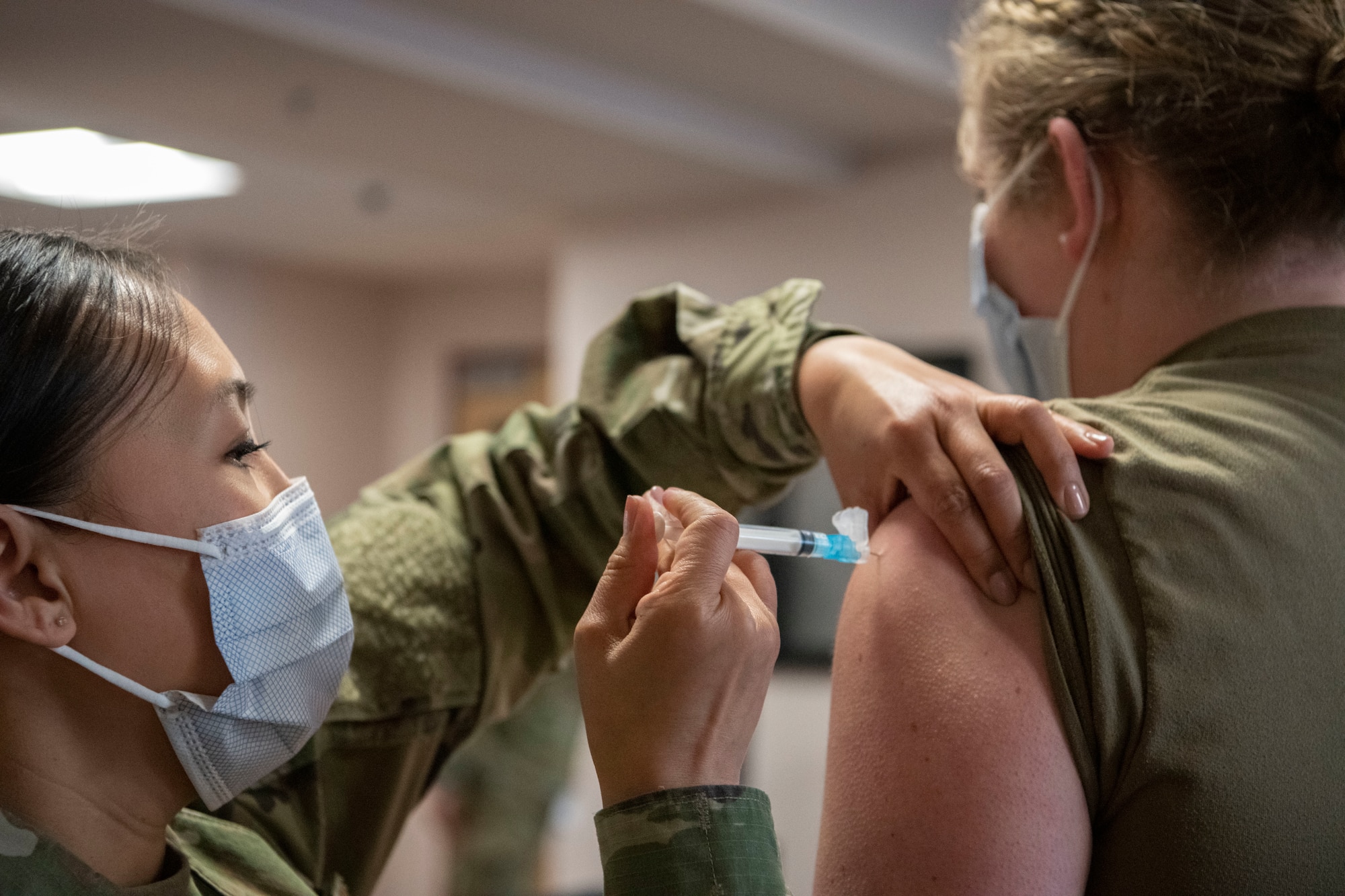 Maj. Suzette Dean, 319th Health Care Operations Squadron family medicine flight commander, administers the COVID-19 vaccine to Staff Sgt. Alexandria Lovell, 319 HCOS family medicine noncommissioned officer in charge, at Grand Forks Air Force Base, N.D., Jan. 21, 2021. The medical team at Grand Forks administered the entire first shipment of vaccines to hundreds of mission essential personnel.