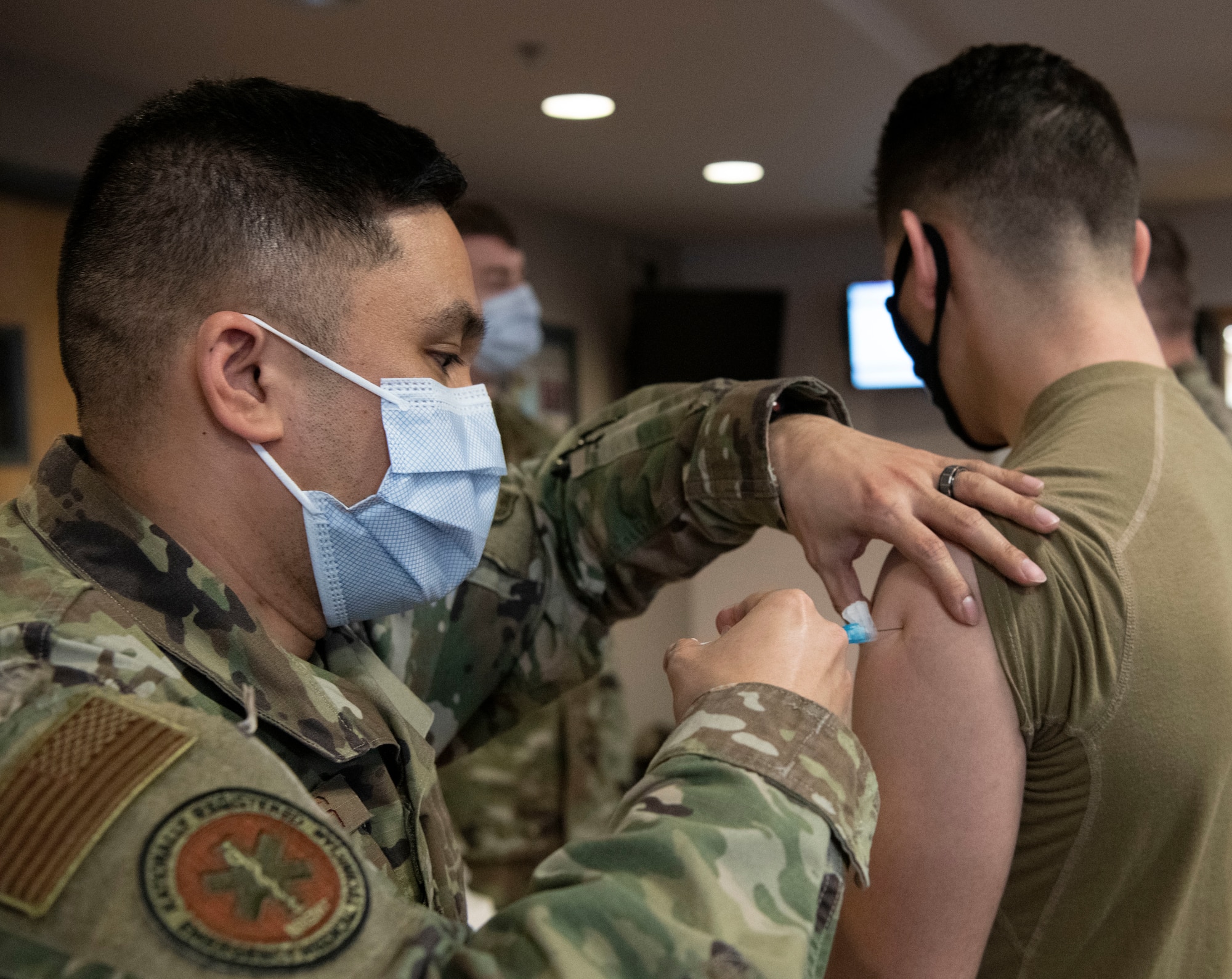 Tech. Sgt. Michael Vasillas, 319th Health Care Operations Squadron aerospace medical technician, administers a COVID-19 vaccine to an airman at Grand Forks Air Force Base, N.D., Jan. 21, 2021. Following vaccination, DoD personnel are still expected to follow CDC guidelines, including the use of masks and physical distancing.