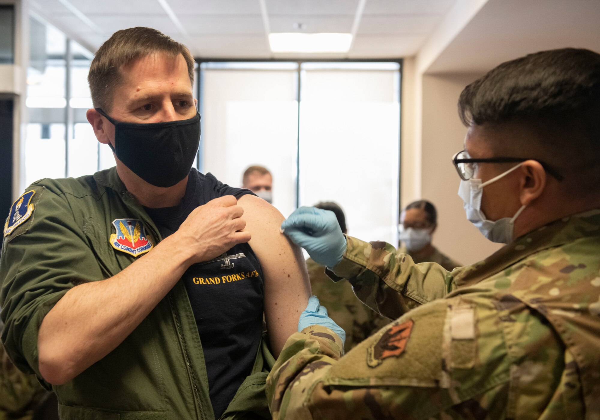 Senior Airman Brandon Ordonez, 319th Health Care Operations Squadron aerospace medical technician, administers a COVID-19 vaccine to Col. Cameron Pringle, 319th Reconnaissance Wing commander, at Grand Forks Air Force Base, N.D., Jan. 22, 2021. The 319 RW received its first shipment of vaccines on Jan. 21 and vaccinated hundreds of mission-essential personnel.