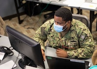 JOINT BASE LANGLEY-EUSTIS, Va. (Jan. 26, 2021) Navy Damage Controlman 2nd Class Thaddeus Malone,  the J35 orders non-commissioned officer at Joint Task Force Civil Support (JTF-CS), updates a mission assignment and task order tracker as part of his watch-standing duties inside the Joint Operations Center at JTF-CS headquarters  during Exercise Sudden Response 21.