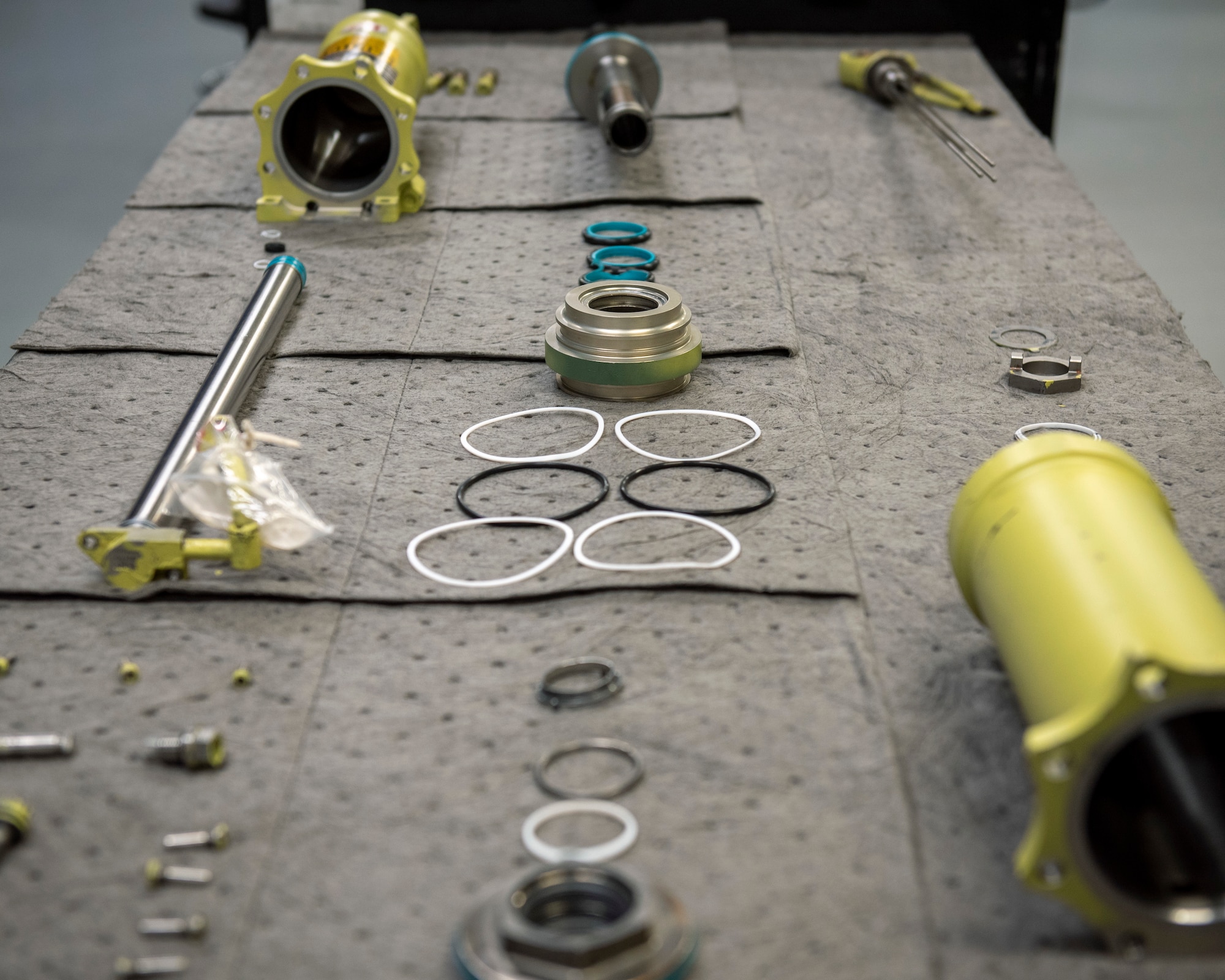 An unassembled hydraulic stabilator actuator from an F-15E Strike Eagle is prepared for reassembly on a work bench at Seymour Johnson Air Force Base, North Carolina, Jan. 7, 2021.