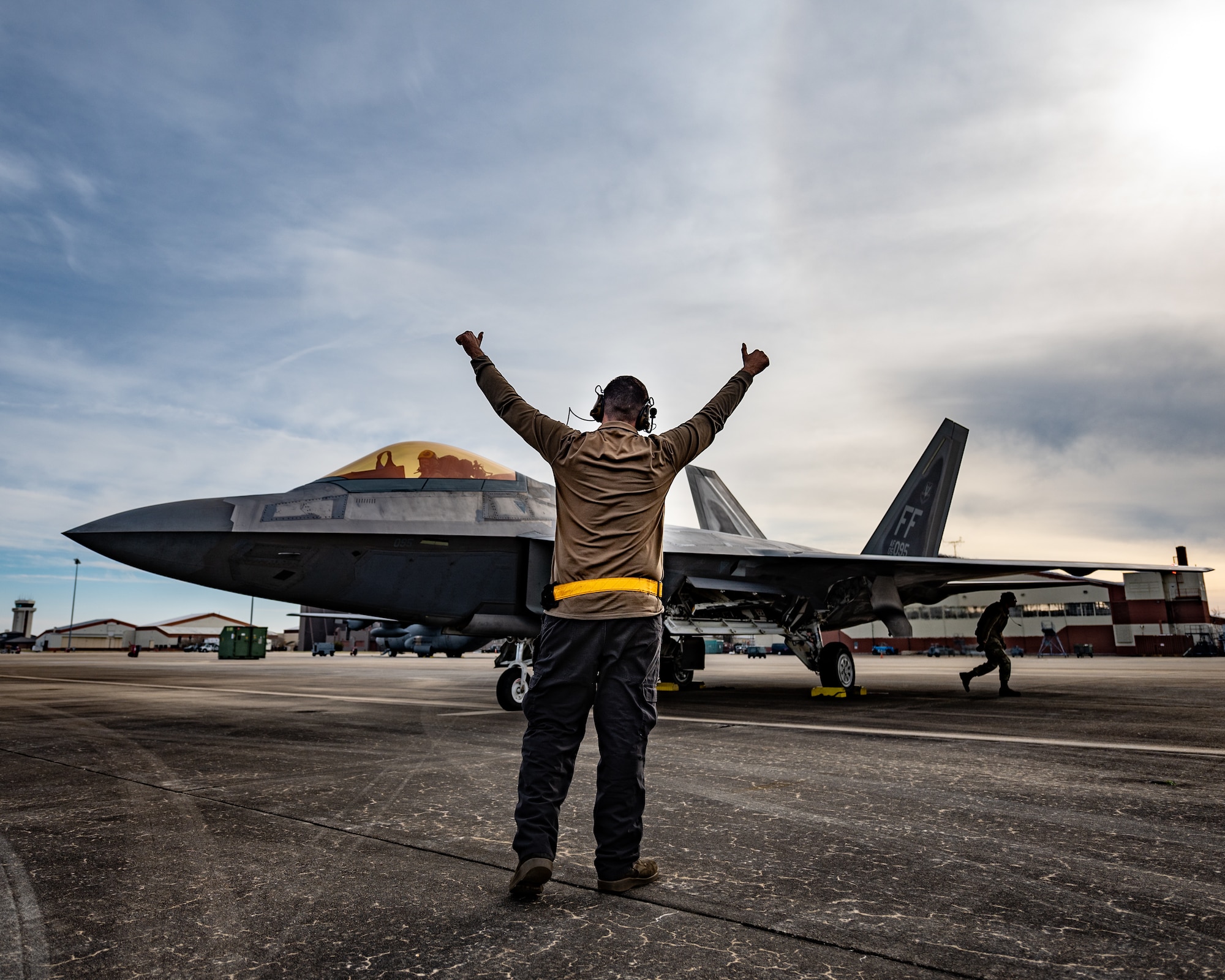 An Airman stands in front of a jet.