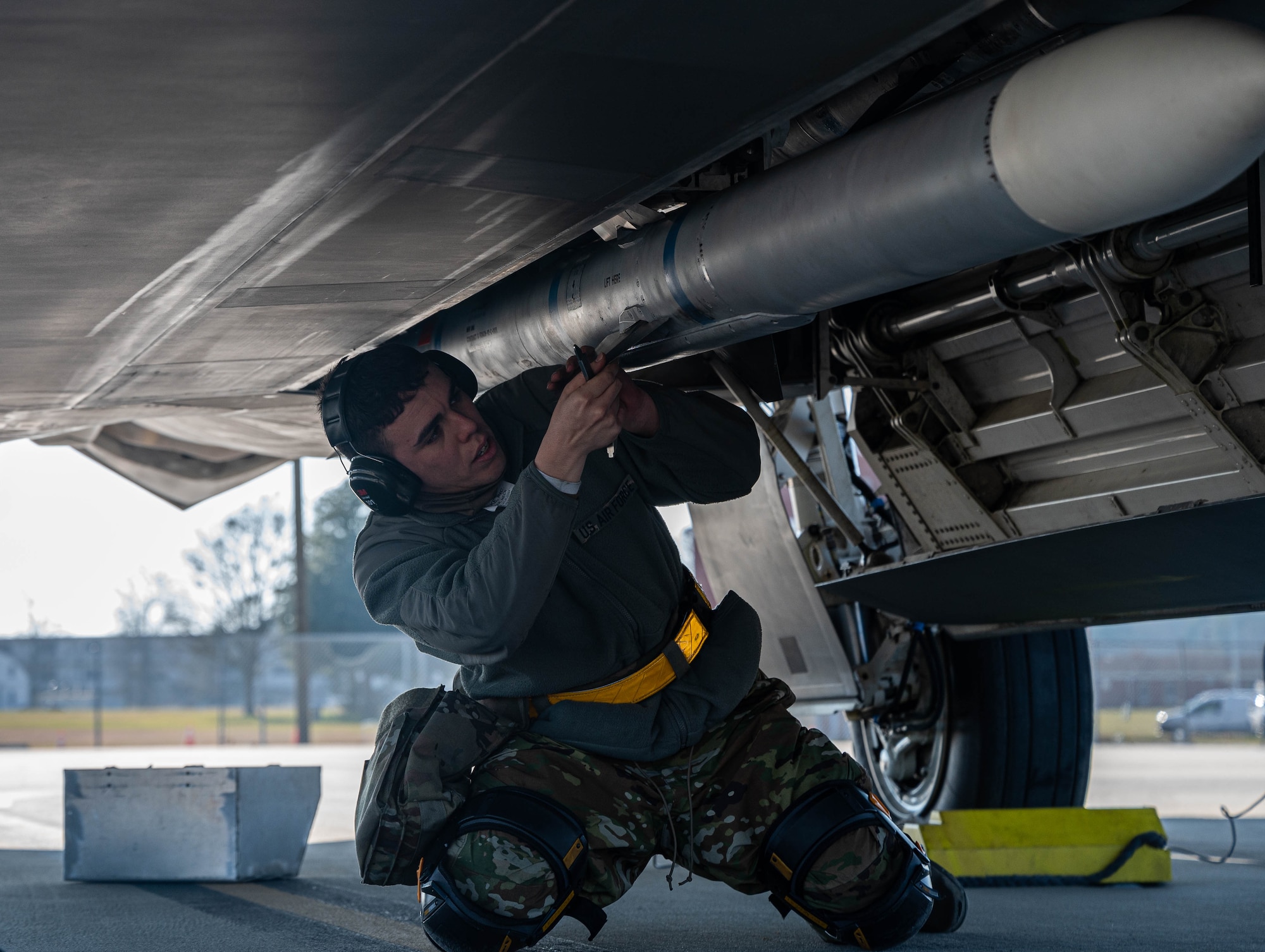 An Airman secures ammunition to an aircraft.