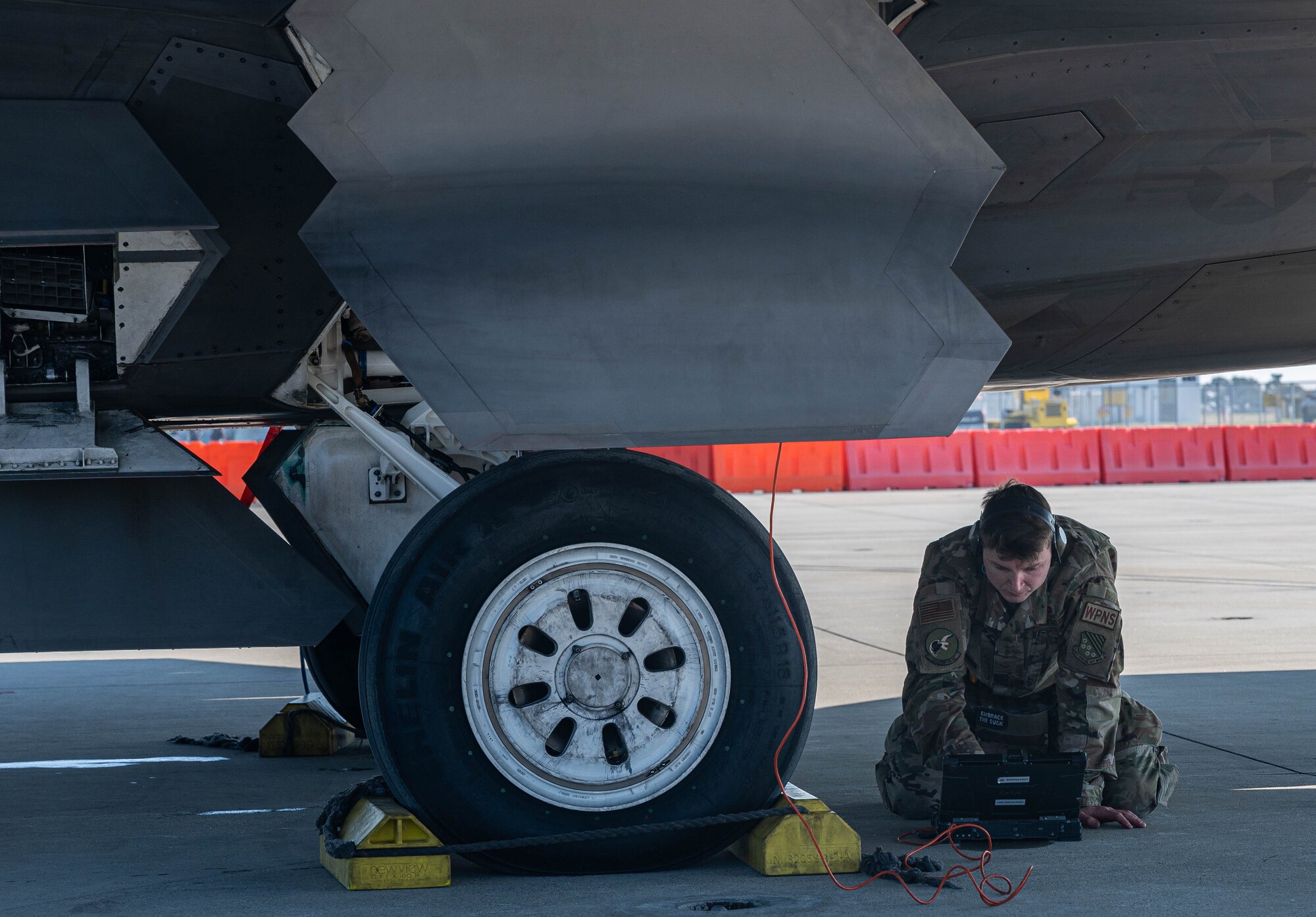 An Airman inspects computer data from an aircraft.