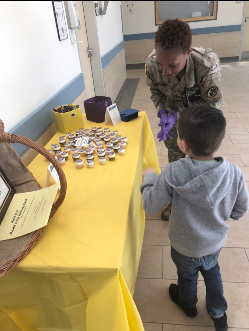 Capt. Ashley Jefferson-Watts, a clinical nurse and officer in charge of the primary care clinic at U.S. Army Health Clinic Grafenwoehr, hands out gifts to a child during a Month of the Military Child event in April 2020.