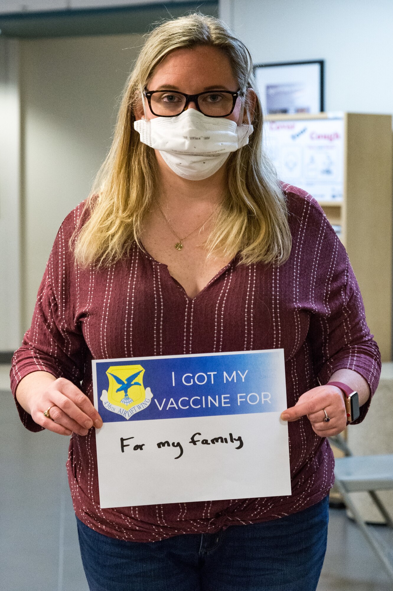 Kathleen McBride, 436th Operational Medical Readiness Squadron aerospace technician, displays a sign stating why she volunteered for the COVID-19 vaccine on Jan. 21, 2021, at Dover Air Force Base, Delaware. McBride was among the first Team Dover front-line workers who voluntarily received the vaccine in accordance with Department of Defense guidance. The vaccine was granted emergency use authorization by the U.S. Food and Drug Administration for use in prevention of COVID-19. (U.S. Air Force photo by Roland Balik)