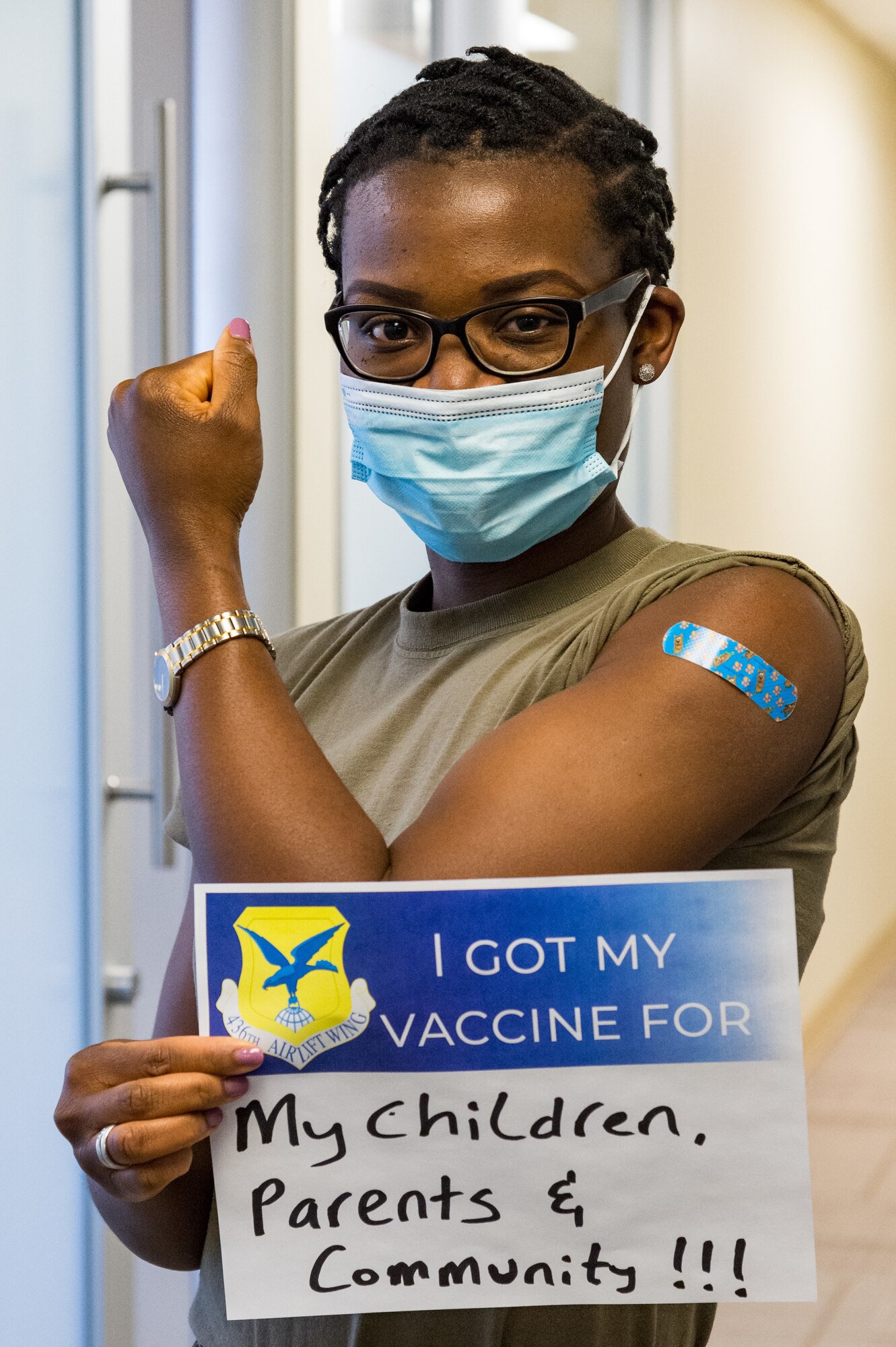 Capt. Lindamira Nkwenti, 436th Medical Group resource management operations flight commander, displays a sign stating why she volunteered for the COVID-19 vaccine on Jan. 21, 2021, at Dover Air Force Base, Delaware. Nkwenti was among the first Team Dover front-line workers who voluntarily received the vaccine in accordance with Department of Defense guidance. The vaccine was granted emergency use authorization by the U.S. Food and Drug Administration for use in prevention of COVID-19. (U.S. Air Force photo by Roland Balik)