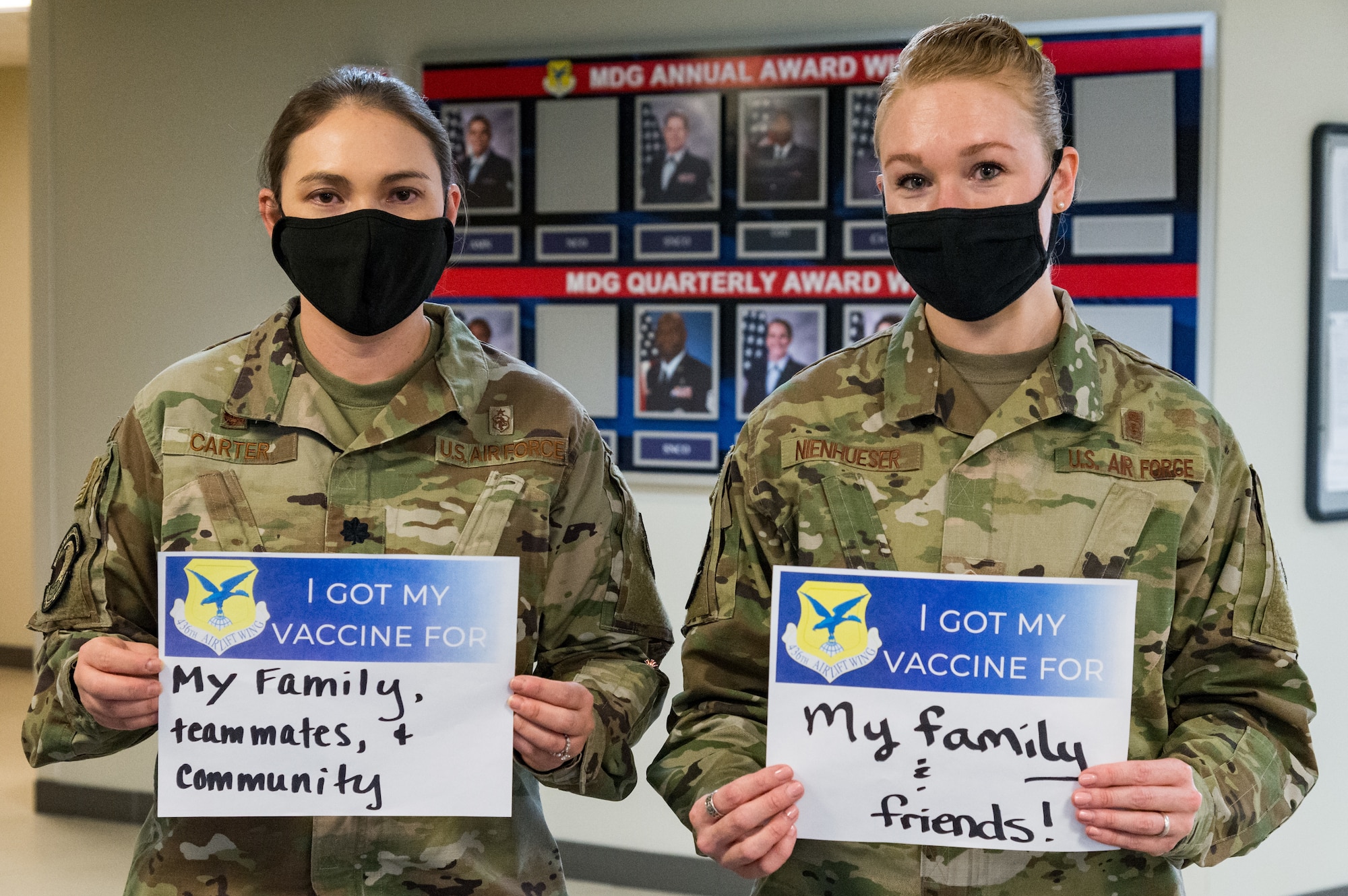 Lt. Col. Kristen Carter, 436th Medical Support Squadron commander, and Master Sgt. Jessica Nienhueser, 436th MDSS superintendent, display their signs stating why they volunteered for the COVID-19 vaccine on Jan. 21, 2021, at Dover Air Force Base, Delaware. Carter and Nienhueser were among the first Team Dover front-line workers who voluntarily received the vaccine in accordance with Department of Defense guidance. The vaccine was granted emergency use authorization by the U.S. Food and Drug Administration for use in prevention of COVID-19. (U.S. Air Force photo by Roland Balik)