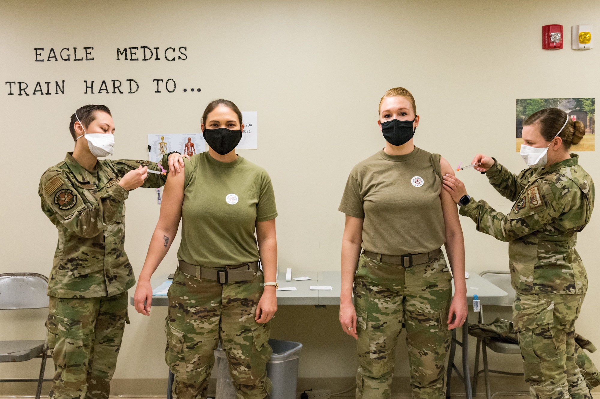 Senior Airman Bianca Robichaud, 436th Health Care Operations Squadron acting family health noncommissioned officer in charge, and Staff Sgt. Kelsey Loeser, 436th Medical Group unit training manager, administer the COVID-19 vaccine to Lt. Col. Kristen Carter, 436th Medical Support Squadron commander, and Master Sgt. Jessica Nienhueser, 436th MDSS superintendent, Jan. 21, 2021, at Dover Air Force Base, Delaware. Carter and Nienhueser were among the first Team Dover front-line workers who voluntarily received the vaccine in accordance with Department of Defense guidance. The vaccine was granted emergency use authorization by the U.S. Food and Drug Administration for use in prevention of COVID-19. (U.S. Air Force photo by Roland Balik)