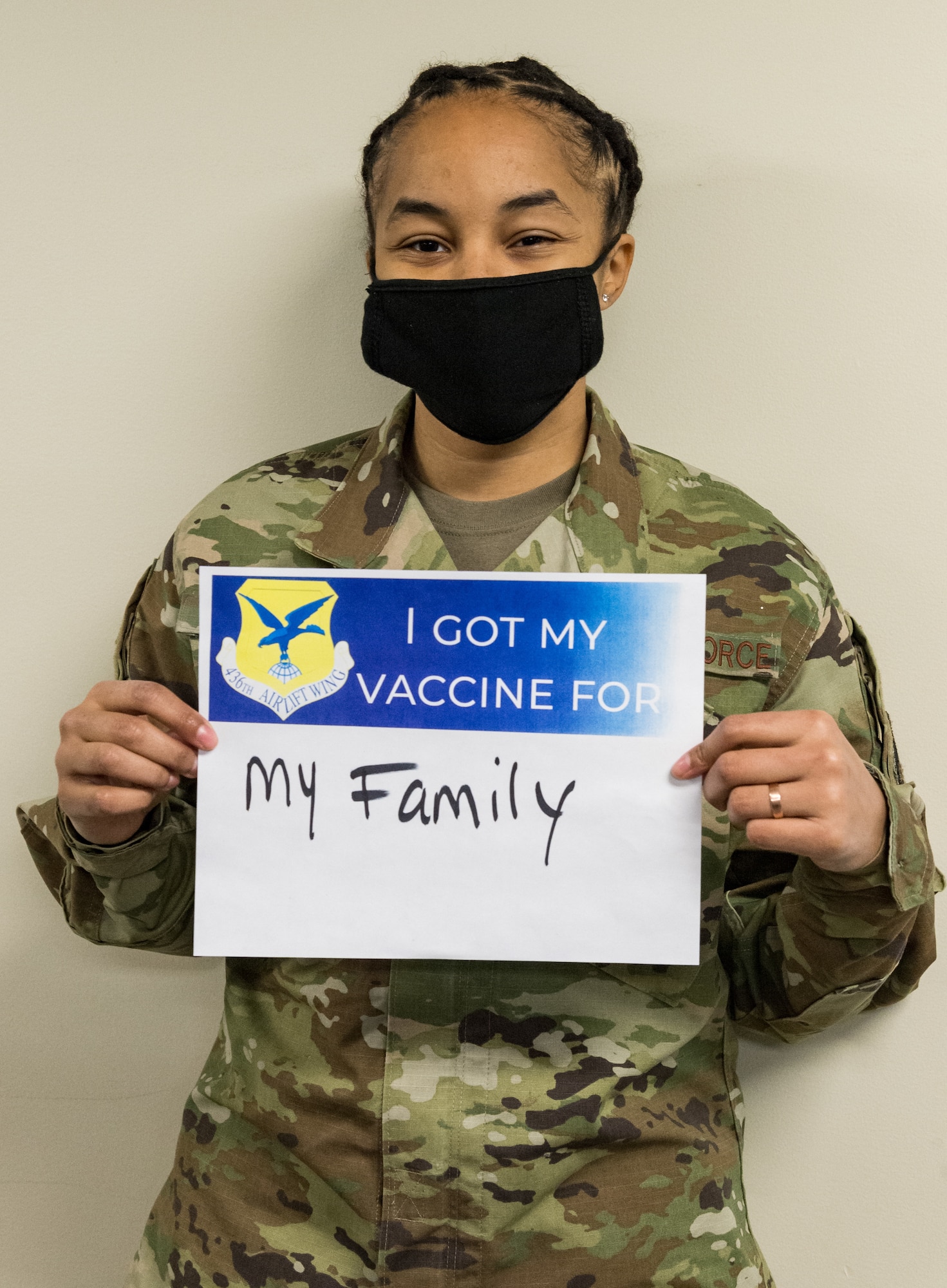 Tech. Sgt. Tiana White, 436th Airlift Wing Tactics and Leadership Nexus cadre, displays a sign stating why she volunteered for the COVID-19 vaccine Jan. 22, 2021, at Dover Air Force Base, Delaware. White was among the first Team Dover members who voluntarily received the vaccine in accordance with Department of Defense guidance. The vaccine was granted emergency use authorization by the U.S. Food and Drug Administration for use in prevention of COVID-19. (U.S. Air Force photo by Roland Balik)