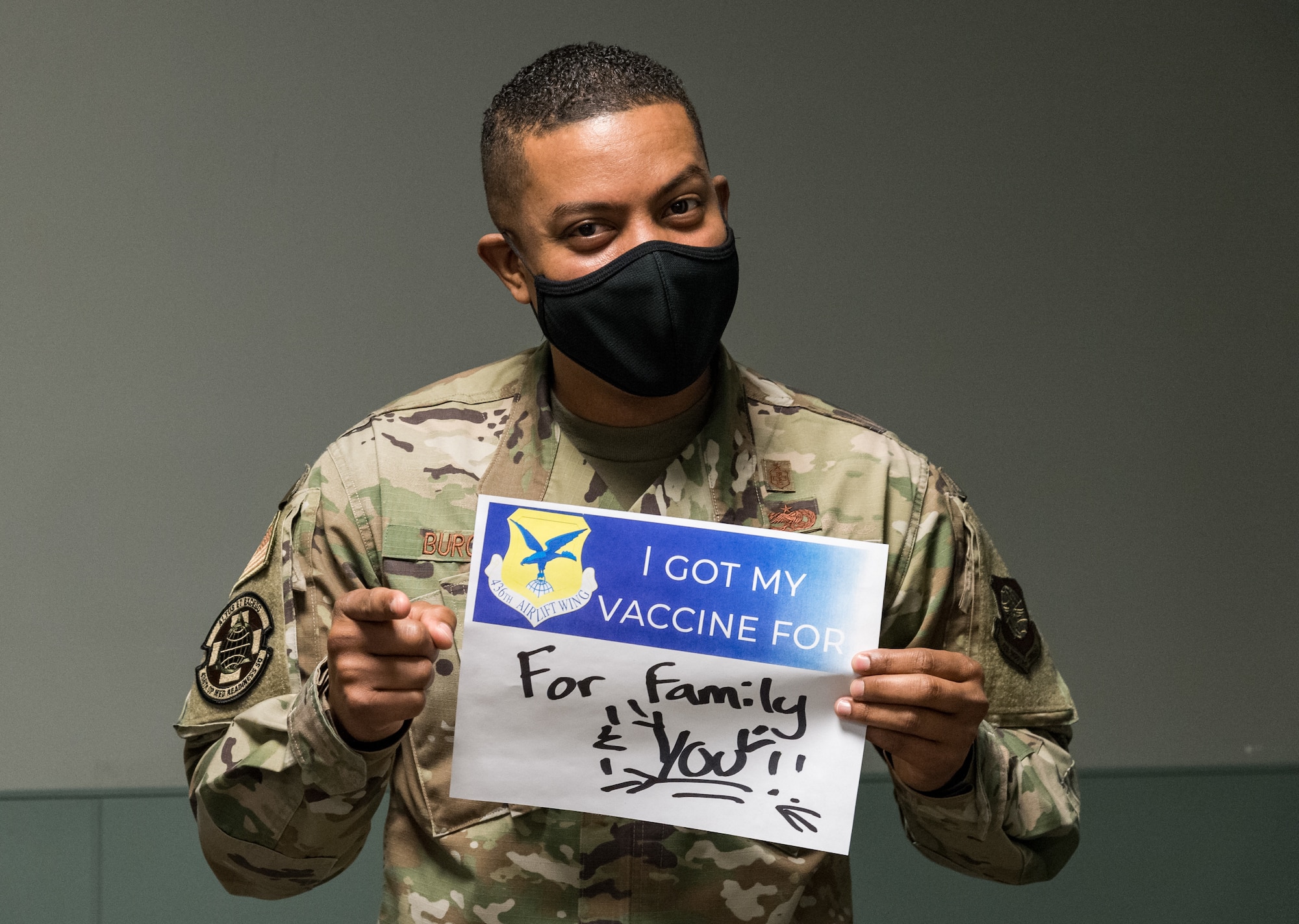 Master Sgt. Andrew Burgos, 436th Operational Medical Readiness Squadron mental health flight chief, displays a sign stating why he volunteered for the COVID-19 vaccine Jan. 20, 2021, at Dover Air Force Base, Delaware. Burgos was among the first Team Dover front-line workers who voluntarily received the vaccine in accordance with Department of Defense guidance. The vaccine was granted emergency use authorization by the U.S. Food and Drug Administration for use in prevention of COVID-19. (U.S. Air Force photo by Roland Balik)