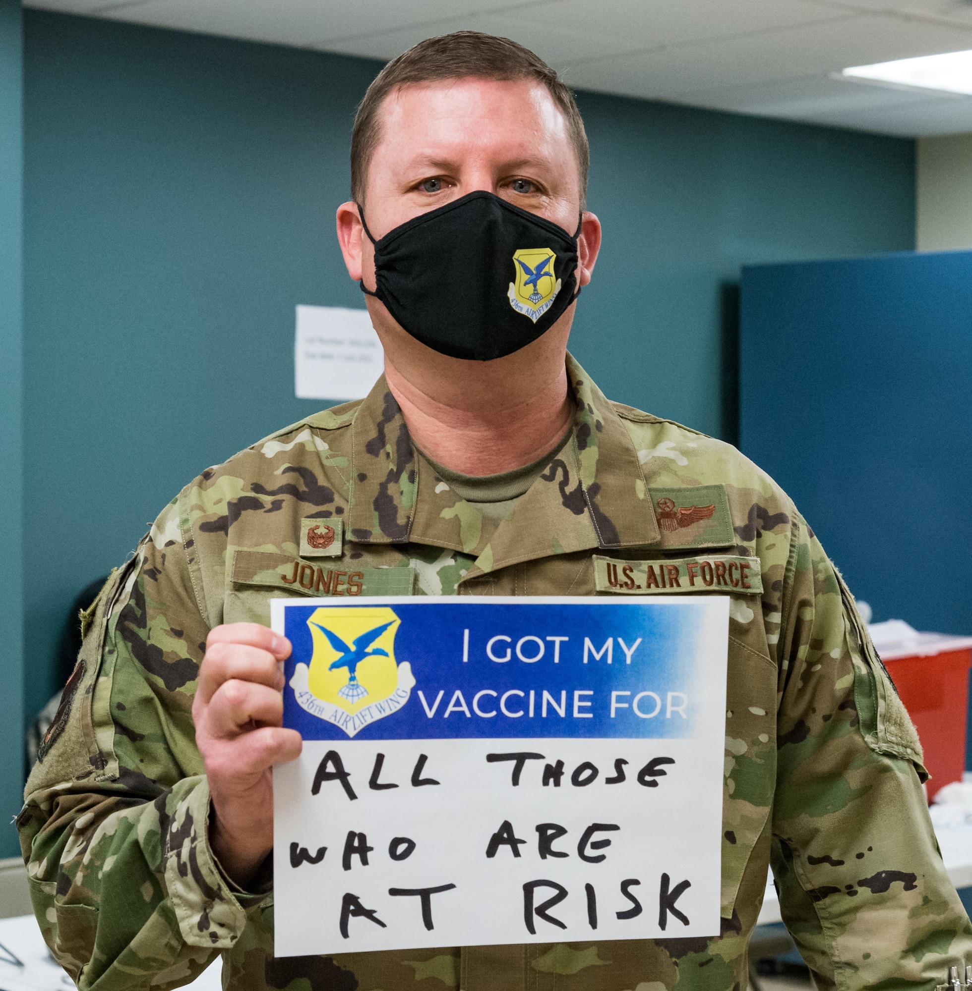 Col. Matthew Jones, 436th Airlift Wing commander, displays a sign stating why he volunteered for the COVID-19 vaccine Jan. 22, 2021, at Dover Air Force Base, Delaware. Jones was among the first Team Dover senior leaders who voluntarily received the vaccine in accordance with Department of Defense guidance. The vaccine was granted emergency use authorization by the U.S. Food and Drug Administration for use in prevention of COVID-19. (U.S. Air Force photo by Roland Balik)