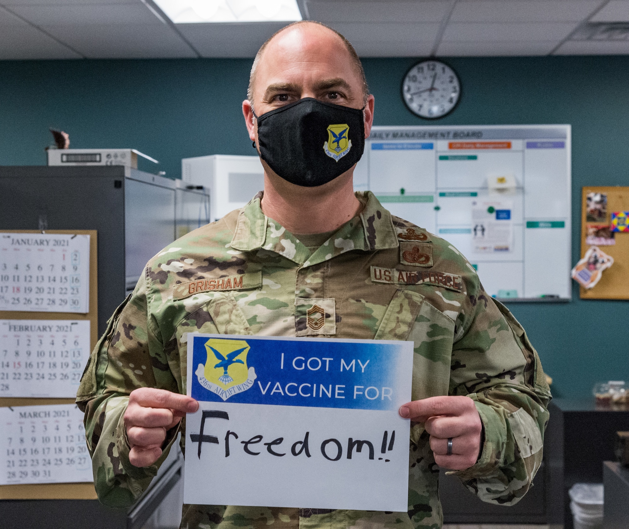 Chief Master Sgt. Jeremiah Grisham, 436th Airlift Wing interim command chief, displays a sign stating why he volunteered for the COVID-19 vaccine Jan. 22, 2021, at Dover Air Force Base, Delaware. Grisham was among the first Team Dover senior leaders who voluntarily received the vaccine in accordance with Department of Defense guidance. The vaccine was granted emergency use authorization by the U.S. Food and Drug Administration for use in prevention of COVID-19. (U.S. Air Force photo by Roland Balik)