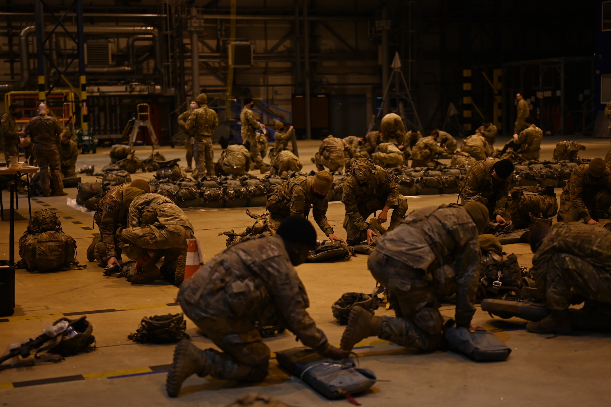U.S. Army paratroopers assigned to the 1st Squadron (Airborne), 91st Cavalry Regiment, 173rd Airborne Brigade, assigned to Grafenwoehr Training Area, Germany, prepare equipment prior to a static line jump.