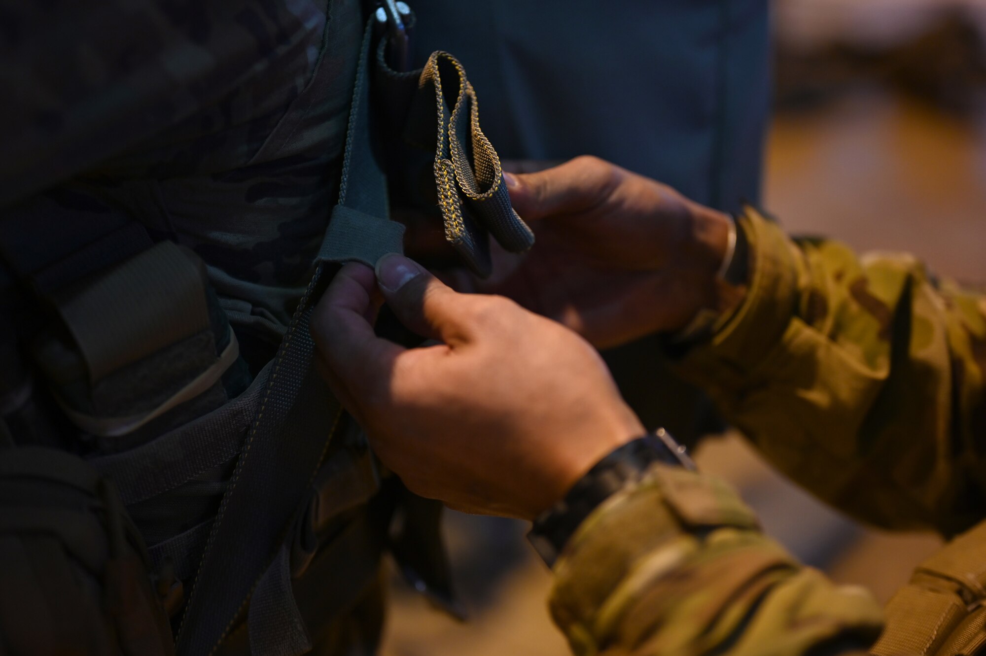 A U.S. Army paratrooper assigned to the 1st Squadron (Airborne), 91st Cavalry Regiment, 173rd Airborne Brigade, assigned to Grafenwoehr Training Area, Germany, tightens the straps of a parachute for another soldier during a buddy-check.