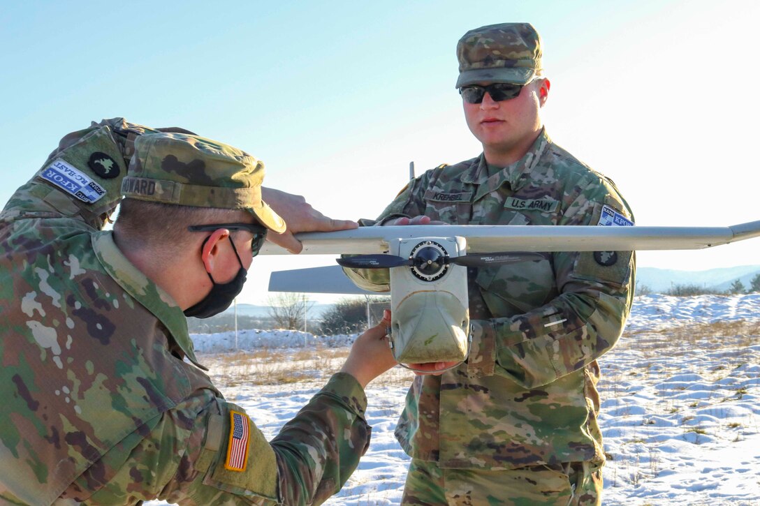 Two guardsmen hold an unmanned aircraft system.