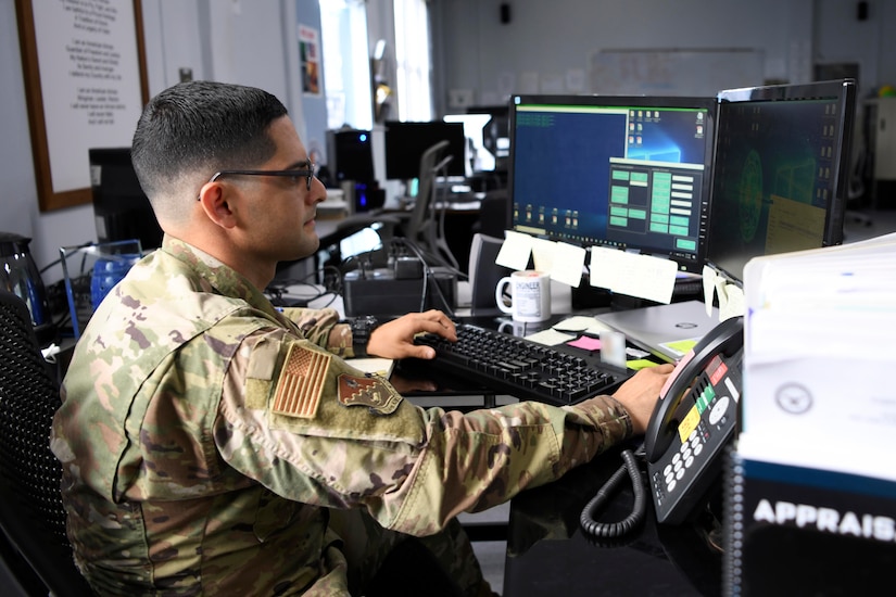 An airman works on a computer.