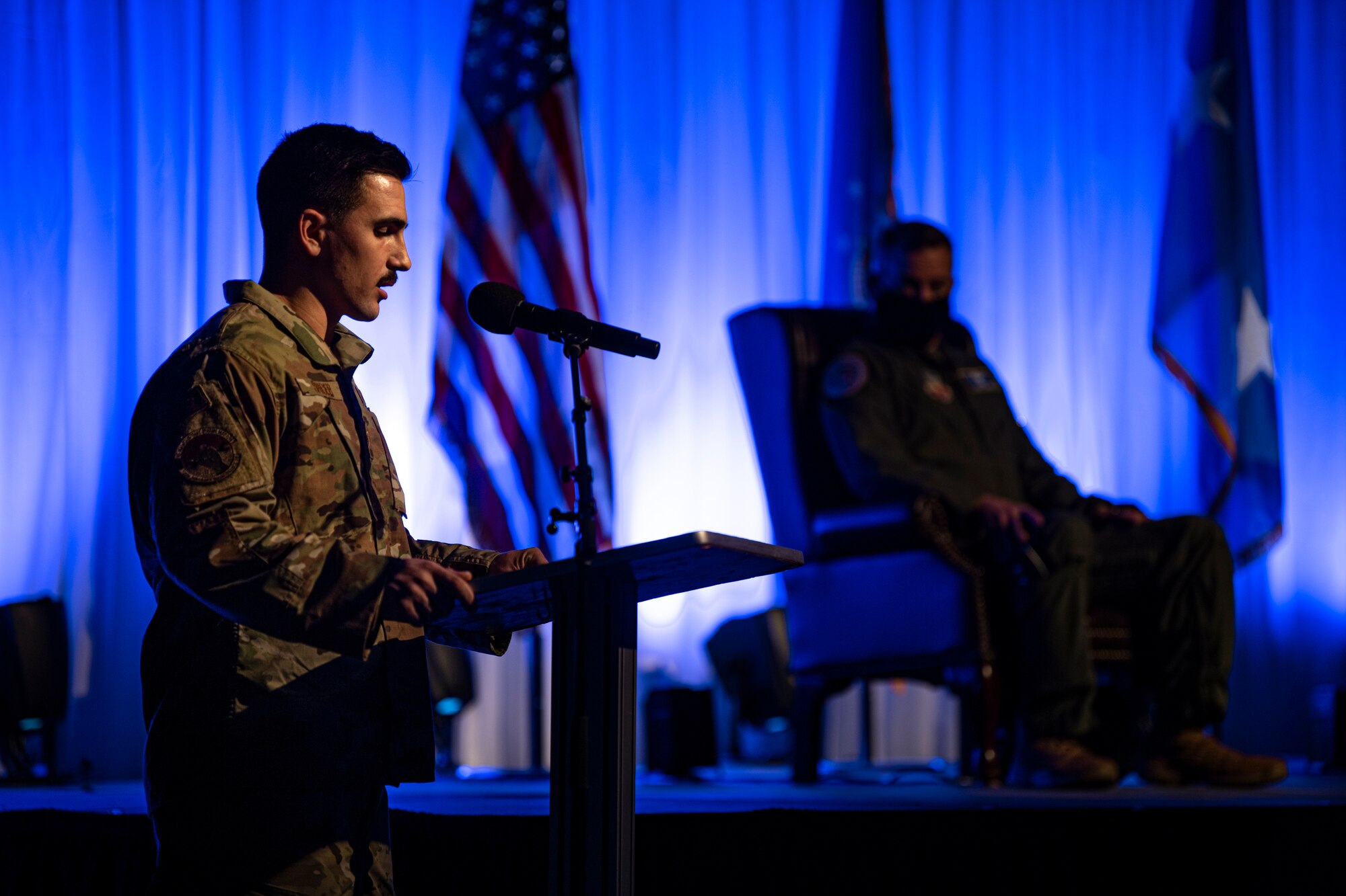 A photo of an Airman introducing special guests during a ceremony