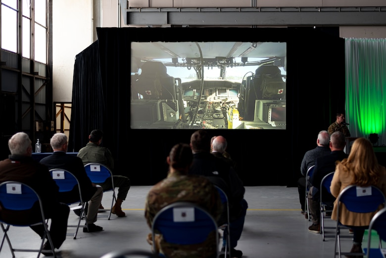 A photo of community members watching a video during a ceremony