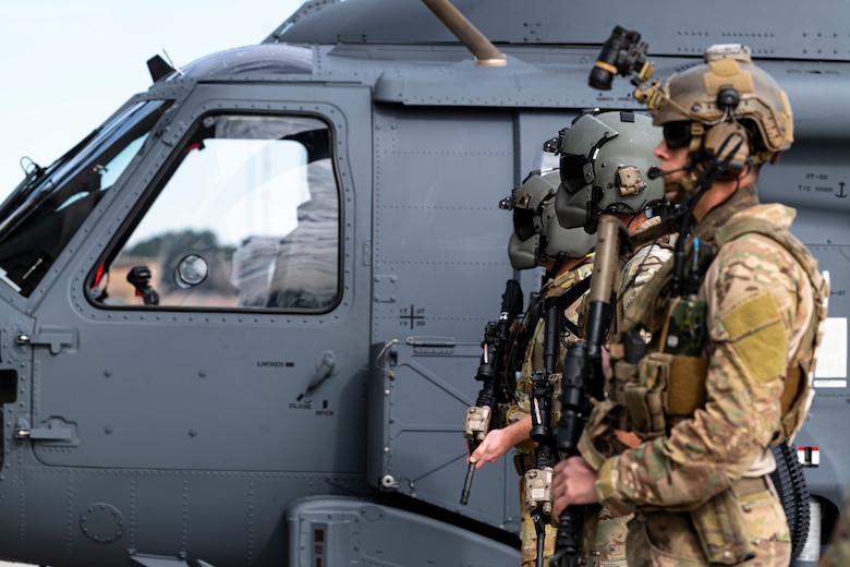 A photo of Airmen posing next to an aircraft