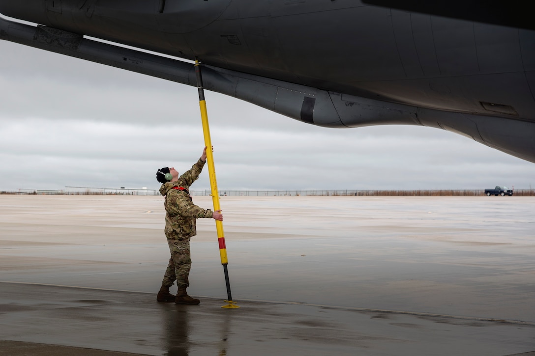 An airman performs maintenance on an aircraft.