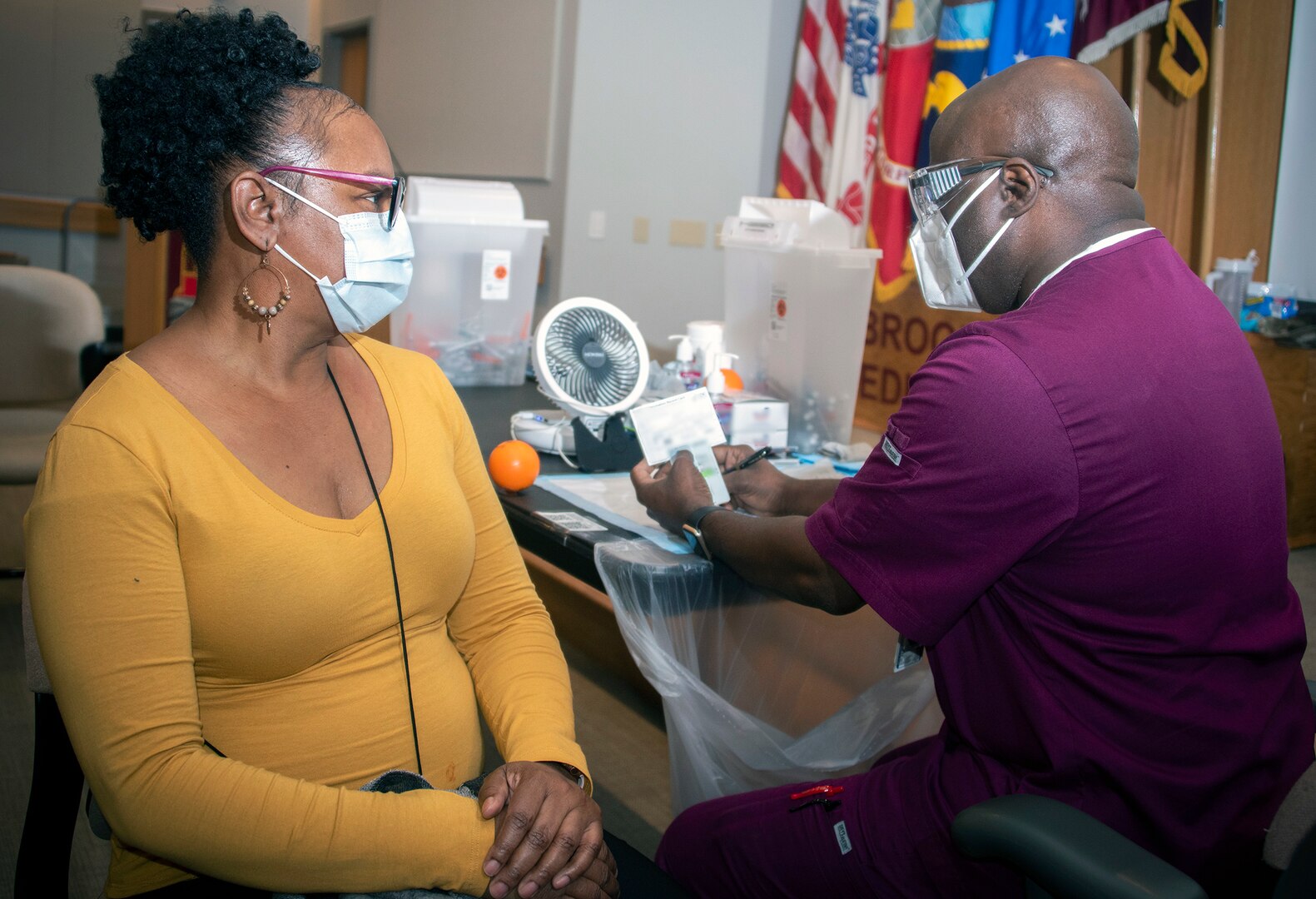 Carlton Chase, licensed vocational nurse, prepares to administer the COVID-19 vaccine to Wanda Elaine Brown, medical clerk, at Brooke Army Medical Center, Joint Base San Antonio-Fort Sam Houston Jan. 26.