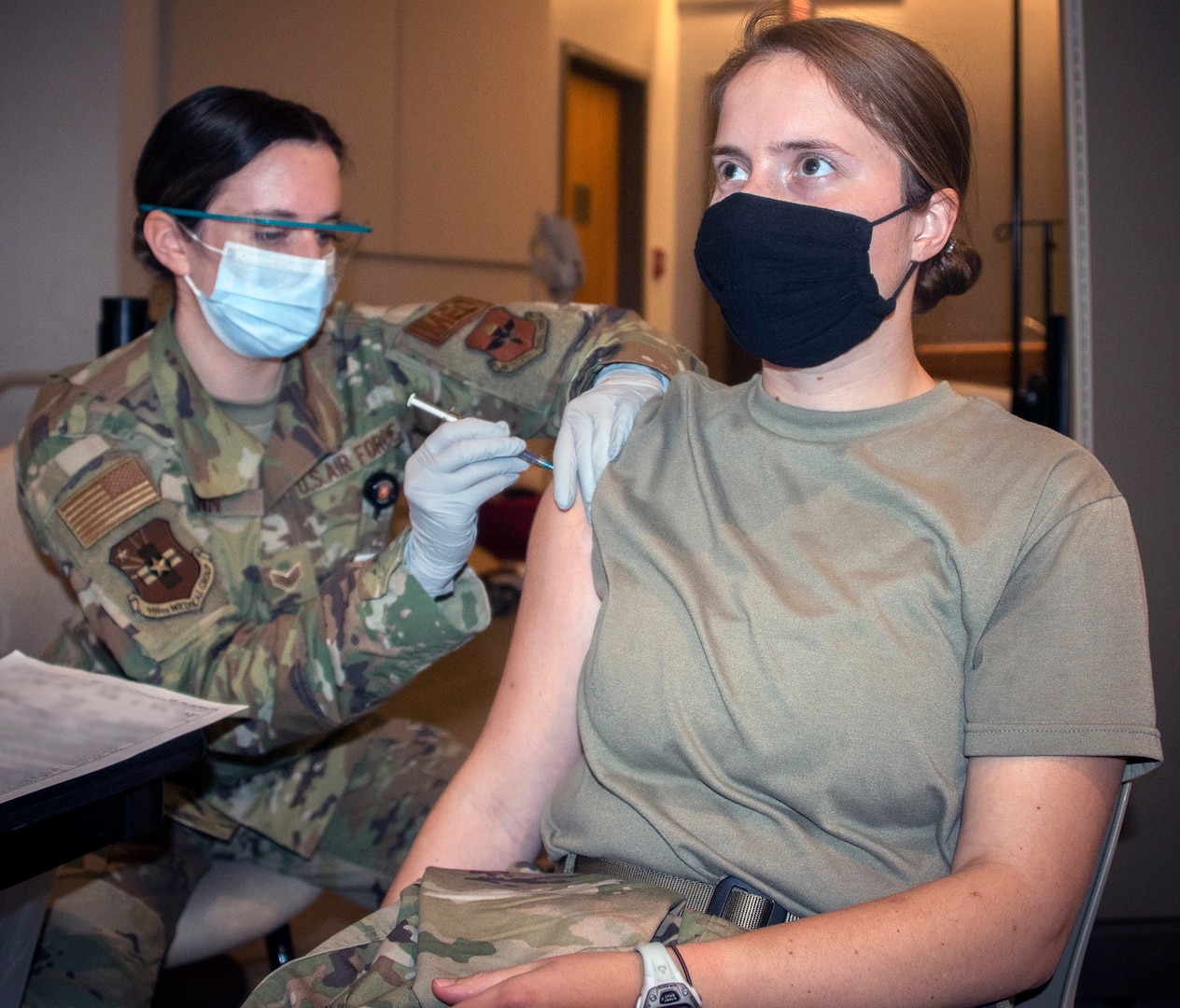 Air Force Senior Airman Kasey Ginn, medical technician, administers the COVID-19 vaccine to Army Capt. Christine Kasprisin, physical therapist, at Brooke Army Medical Center, Joint Base San Antonio-Fort Sam Houston Jan. 26.