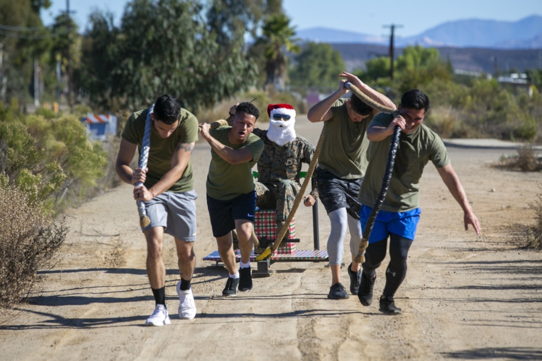 U.S. Marines with Headquarters and Headquarters Squadron, Marine Corps Air Station Miramar, pull Santa’s sled during the monthly H&HS warrior games competition on MCAS Miramar, San Diego, California, Dec. 15, 2020. The goals of the squadron warrior games are to bring comradery and foster teamwork, while exposing the Marines to a challenging workout. (U.S. Marine Corps photo by Lance Cpl. Krysten Houk)