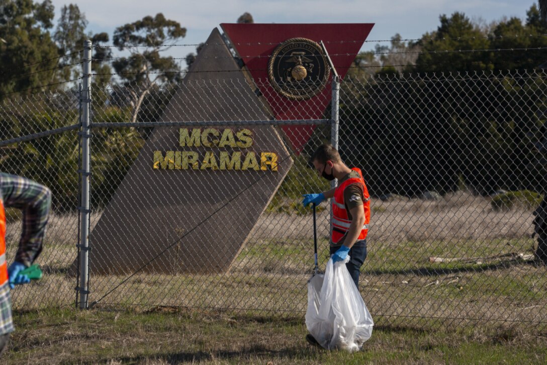 U.S. Marine Corps Lance Cpl. Stephen Booth, an air traffic controller with Headquarters and Headquarters Squadron, Marine Corps Air Station Miramar, picks up trash during a volunteer event with the Single Marine Program outside of MCAS Miramar, San Diego, California, Jan. 13, 2021. The SMP hosted the volunteer cleanup event to remove trash along the station's perimeter to clean up the heavily-trafficked and often-polluted area, and ensure that the station Marines remain excellent environmental stewards of the surrounding area. (U.S. Marine Corps photo by Lance Cpl. Krysten Houk)
