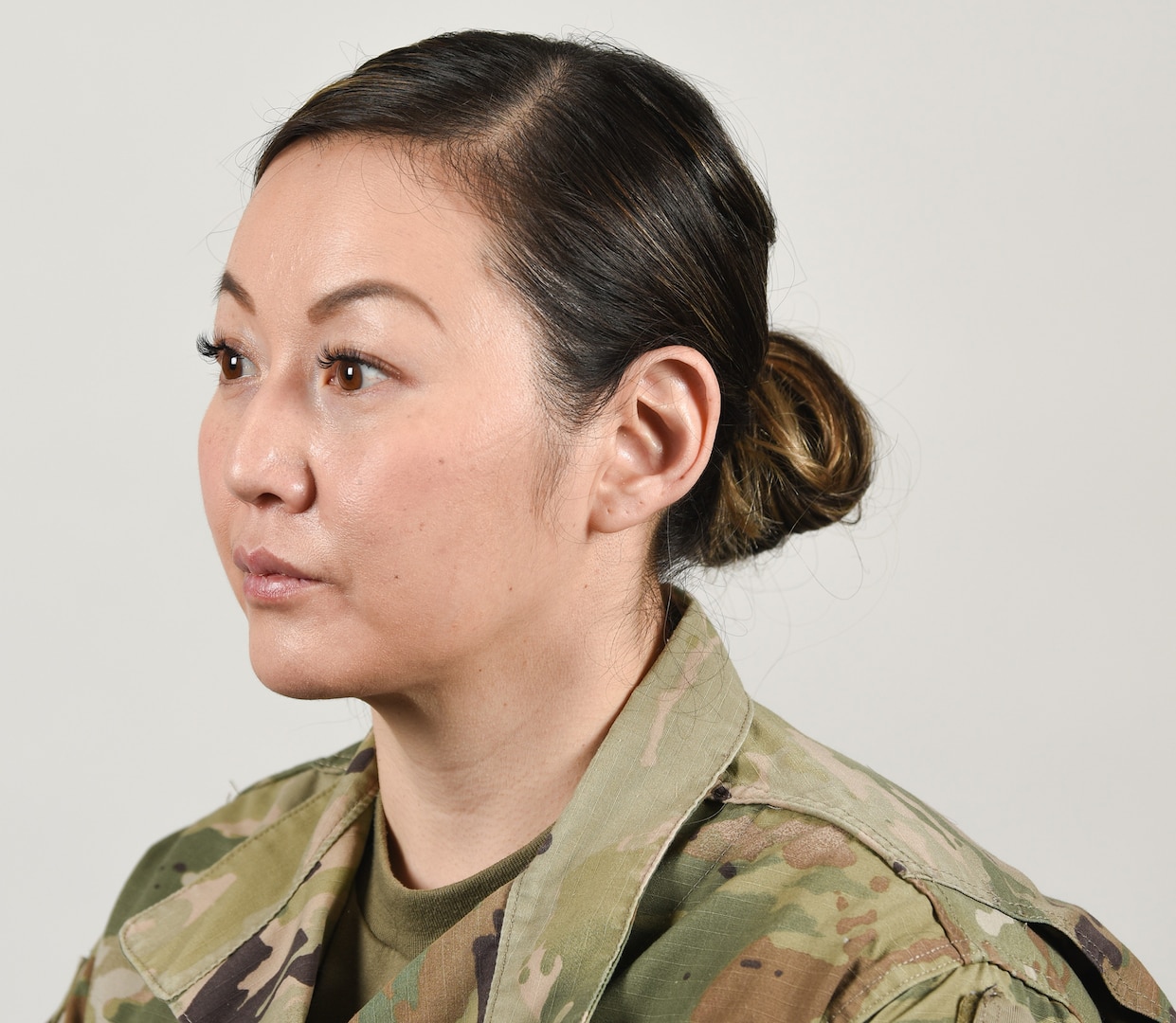 A female Soldier poses for an example photo with medium-length hair secured into a ponytail to support an upcoming change in Army grooming and appearance standards. Medium-length ponytails are only authorized for wear on the back of the scalp and cannot exceed the head's width or interfere with a Soldier's headgear.