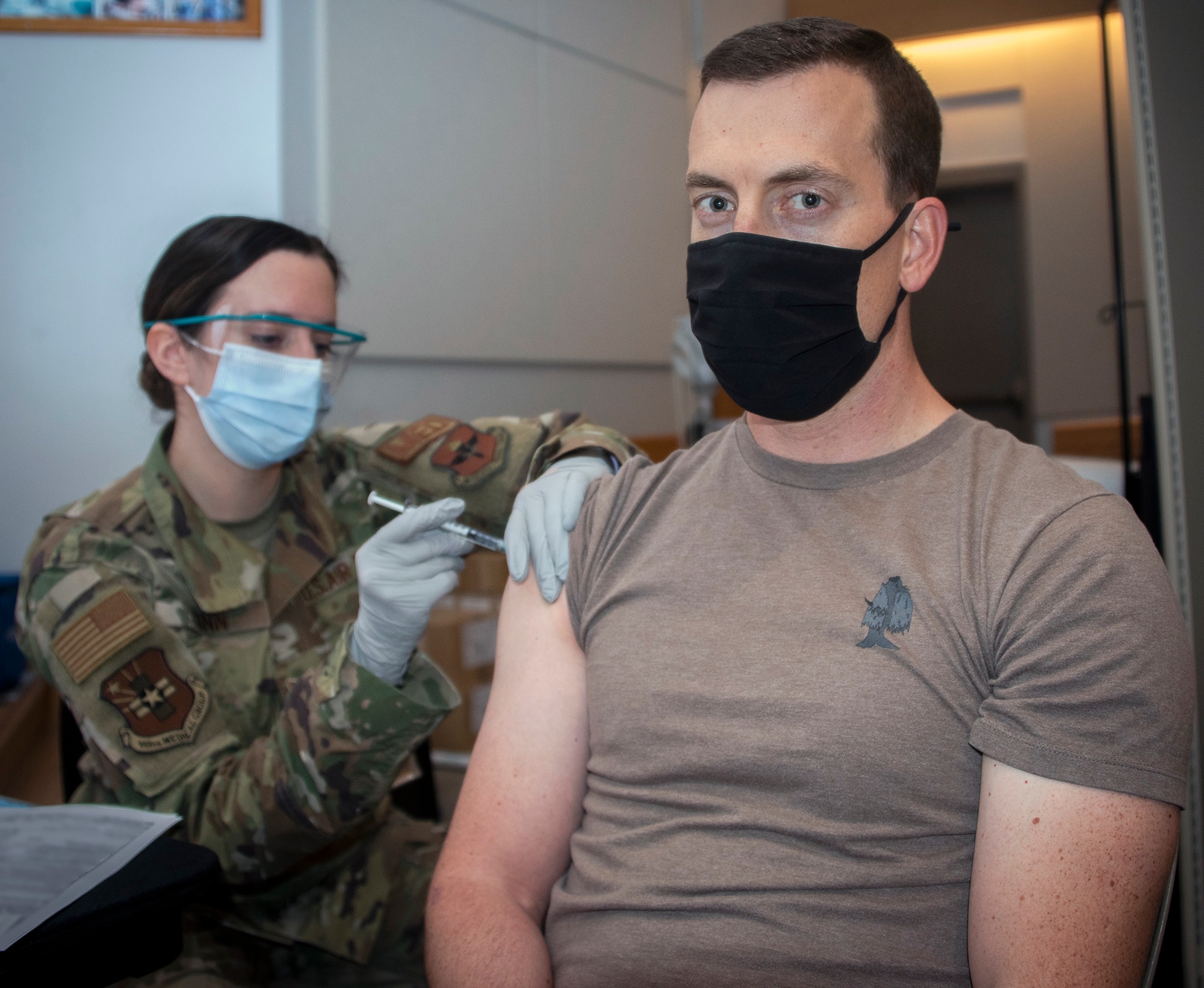 Air Force Senior Airman Kasey Ginn, medical technician, administers the COVID-19 vaccine to Navy Lt. Cmdr. Matthew Bush, physical therapy fellow, at Brooke Army Medical Center, Joint Base San Antonio-Fort Sam Houston Jan. 26.