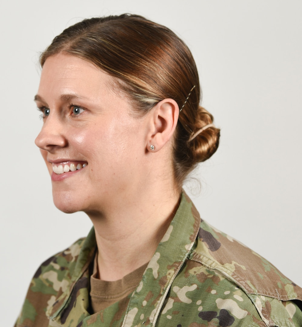 A female Soldier poses for an example photo with natural-colored highlights and wearing stud earrings in her Army Combat Uniform to illustrate an upcoming change to Army grooming and appearance standards. Female Soldiers will soon be authorized to wear earrings in their ACU if it meets the current size and dimensions standards. Individuals will not be allowed to wear earrings in a field environment or during a combat-related deployment, or in locations where access to regular hygiene is limited.